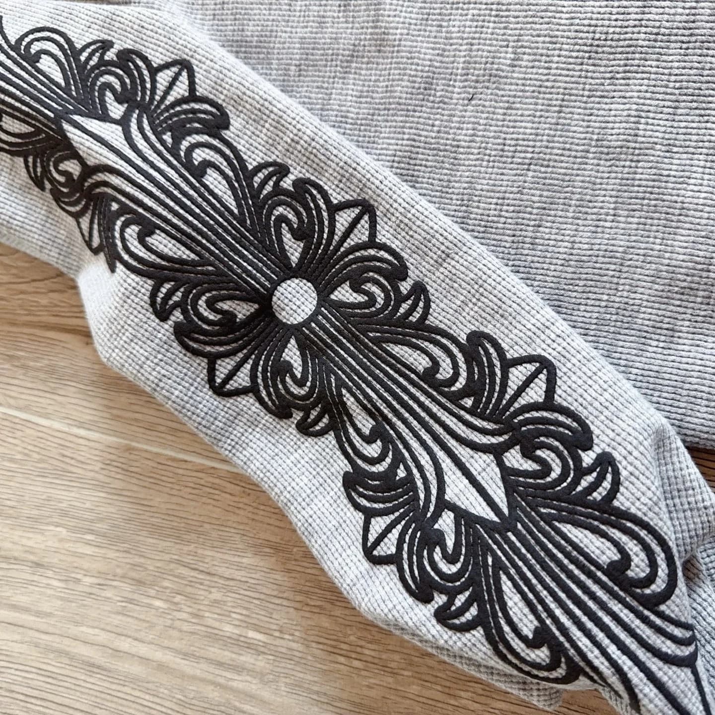 Черный готический узор на рукаве серого лонгслива Chrome Hearts