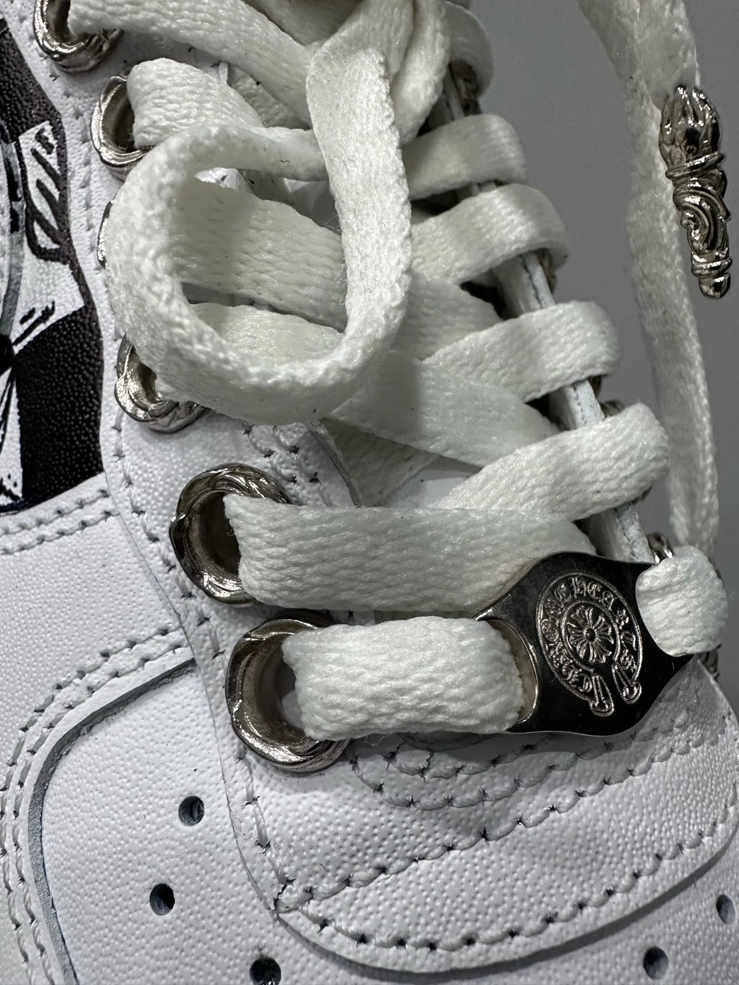 Деталь шнуровки кроссовок Chrome Hearts x Nike Air Force 1 Matty Boy с серебряным дюбре и люверсами
