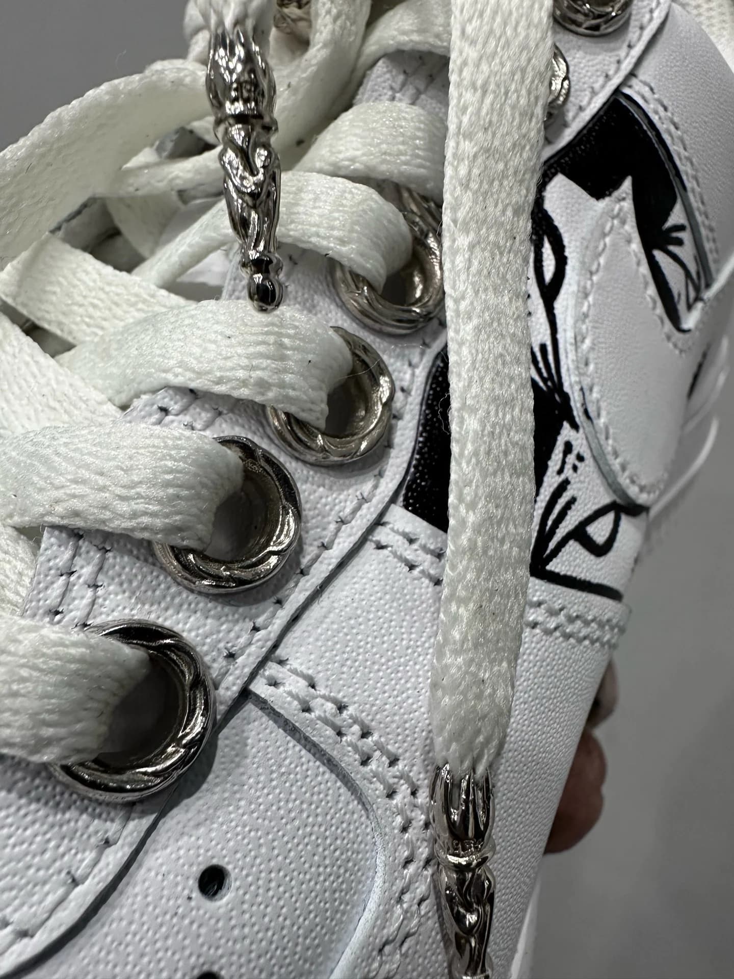 Крупный план серебряной фурнитуры Chrome Hearts на шнурках кроссовок Nike Air Force 1