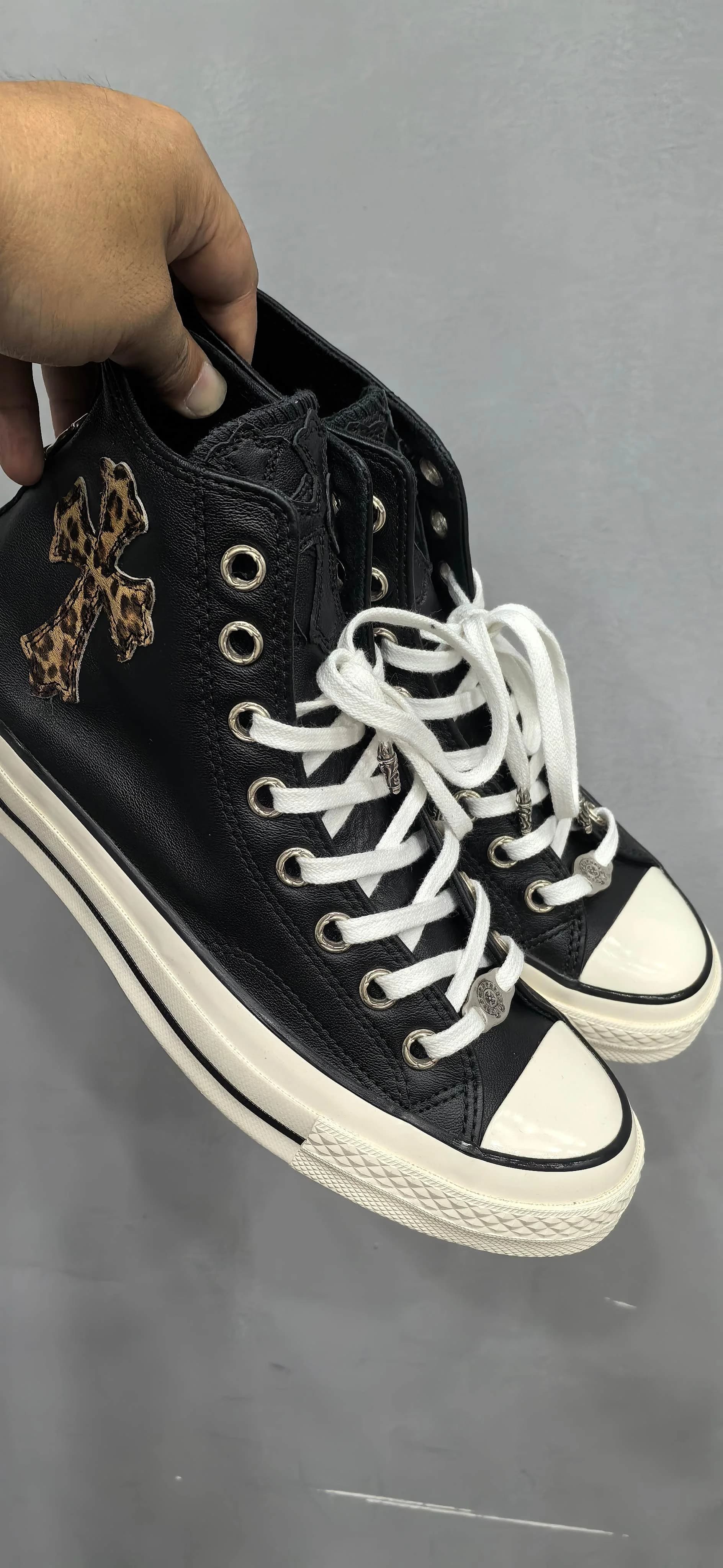 Черные высокие кеды Chrome Hearts Converse Chuck 70 Custom в руке