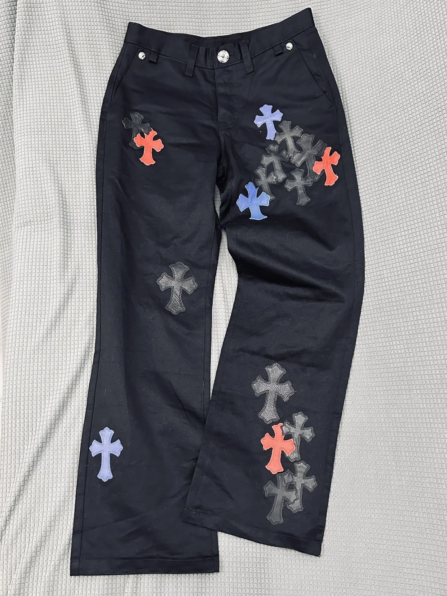 Черные брюки Chrome Hearts с разноцветными кожаными нашивками-крестами, вид спереди