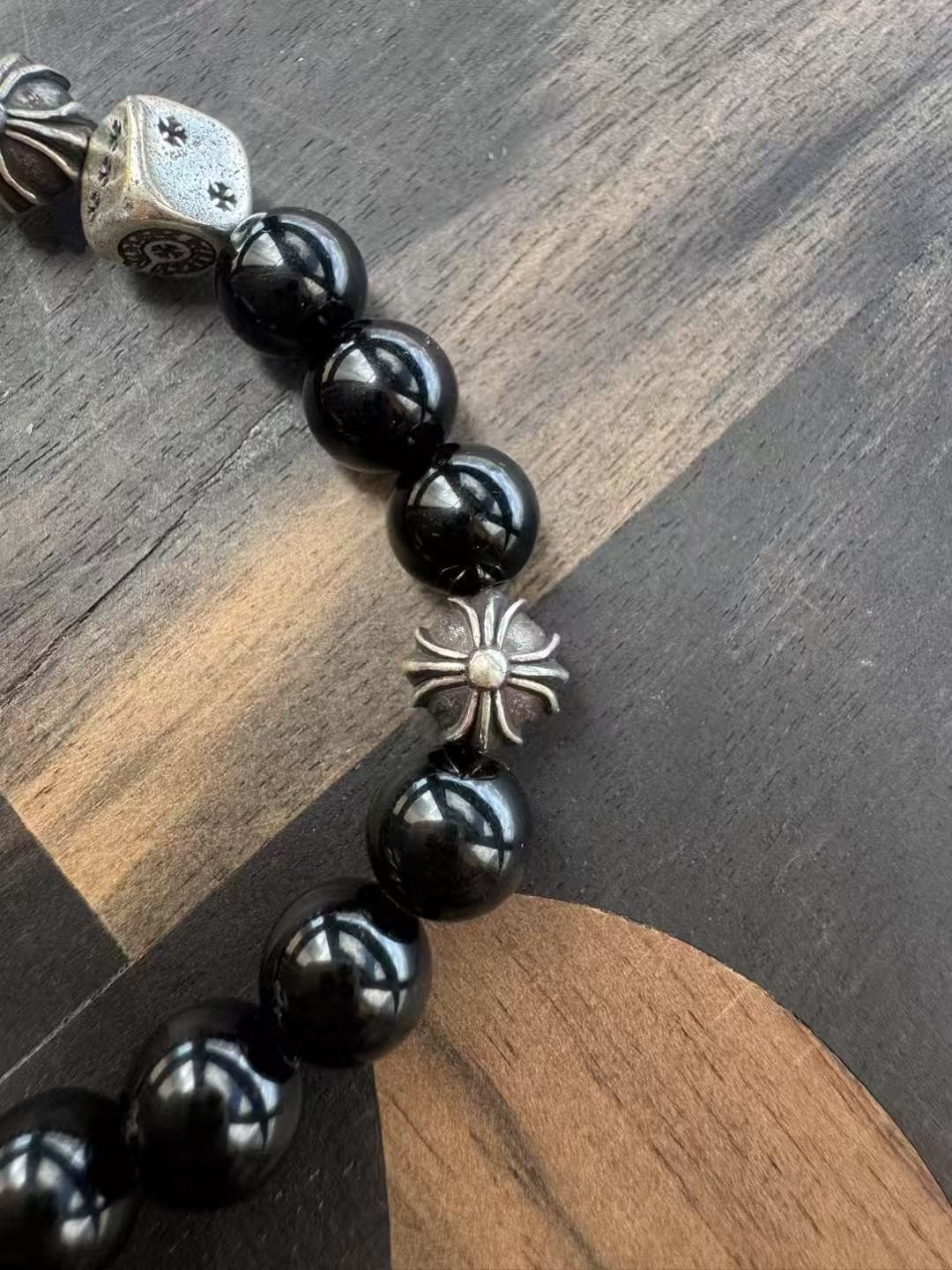 Деталь браслета Chrome Hearts с черными бусинами и серебряным элементом Cross Ball