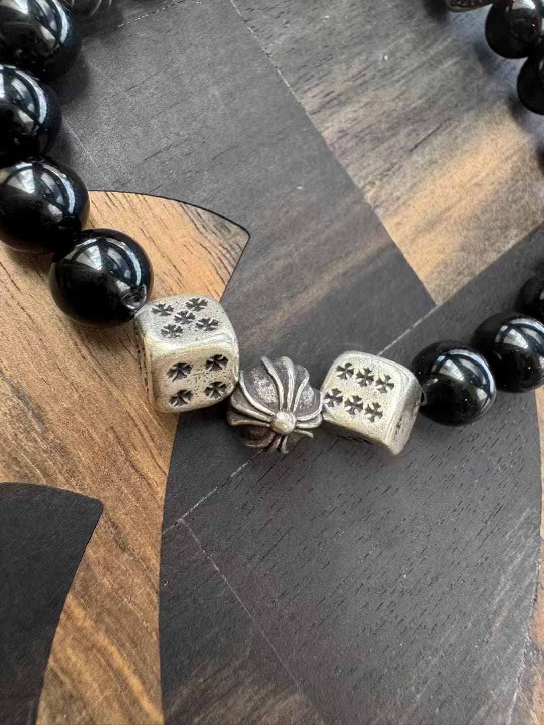 Крупный план серебряных игральных костей Dice с крестами на браслете Chrome Hearts