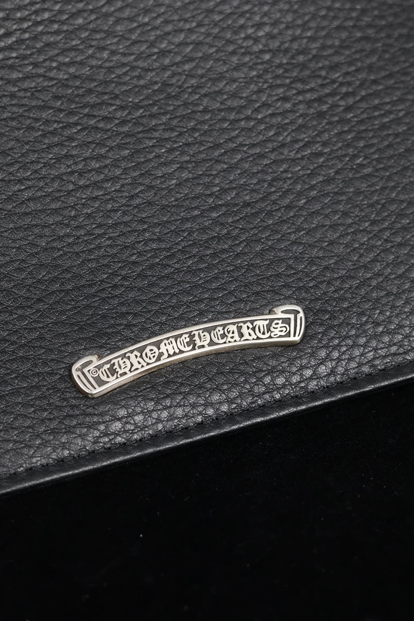 Крупный план серебряной накладки с логотипом Chrome Hearts
