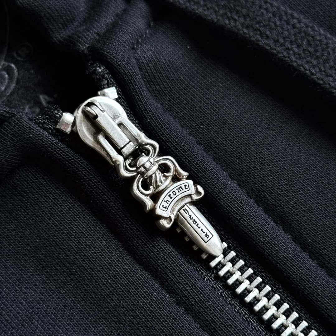 Металлическая молния с пуллером в виде кинжала на черном зип-худи Chrome Hearts