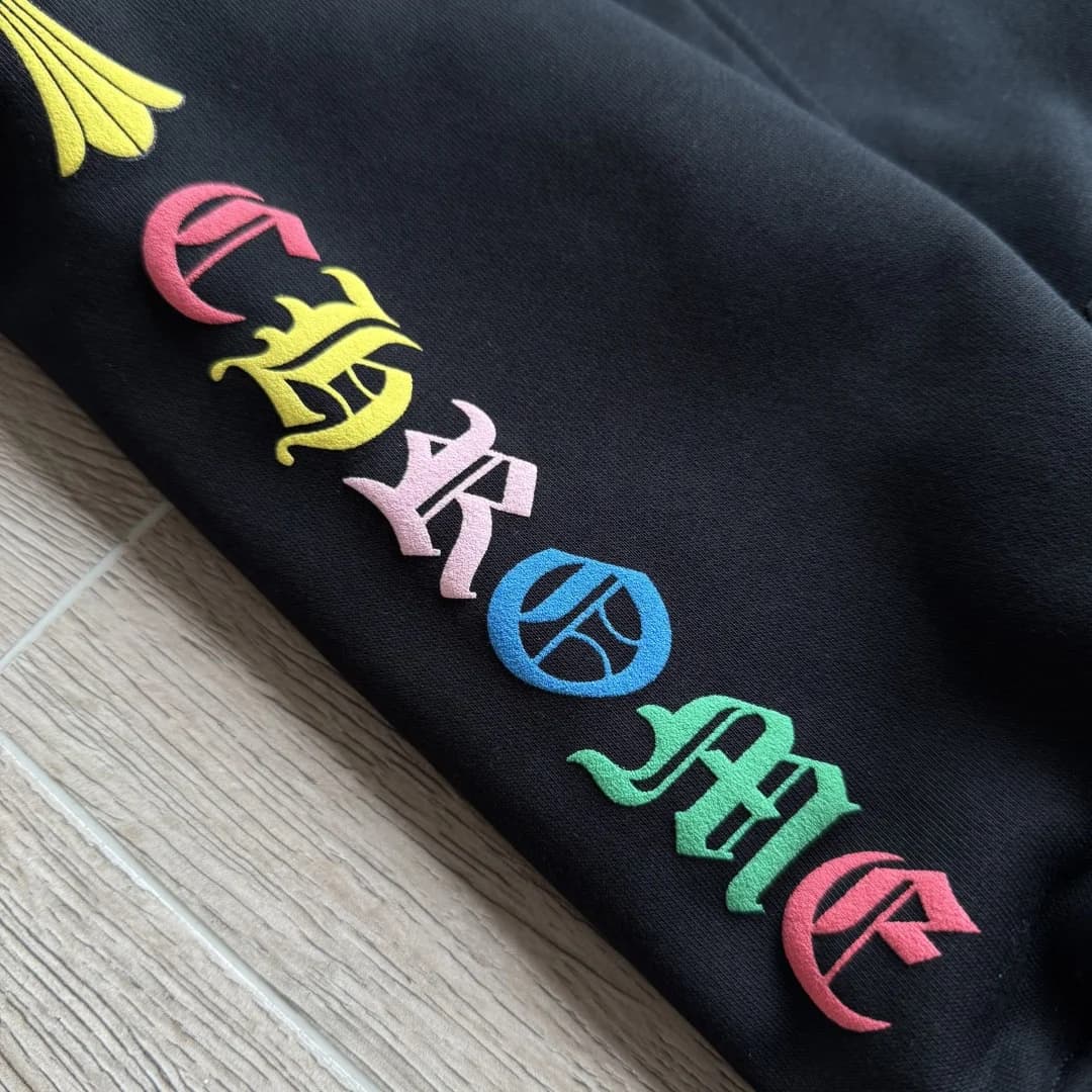 Крупный план разноцветного принта на рукаве черного зип-худи Chrome Hearts