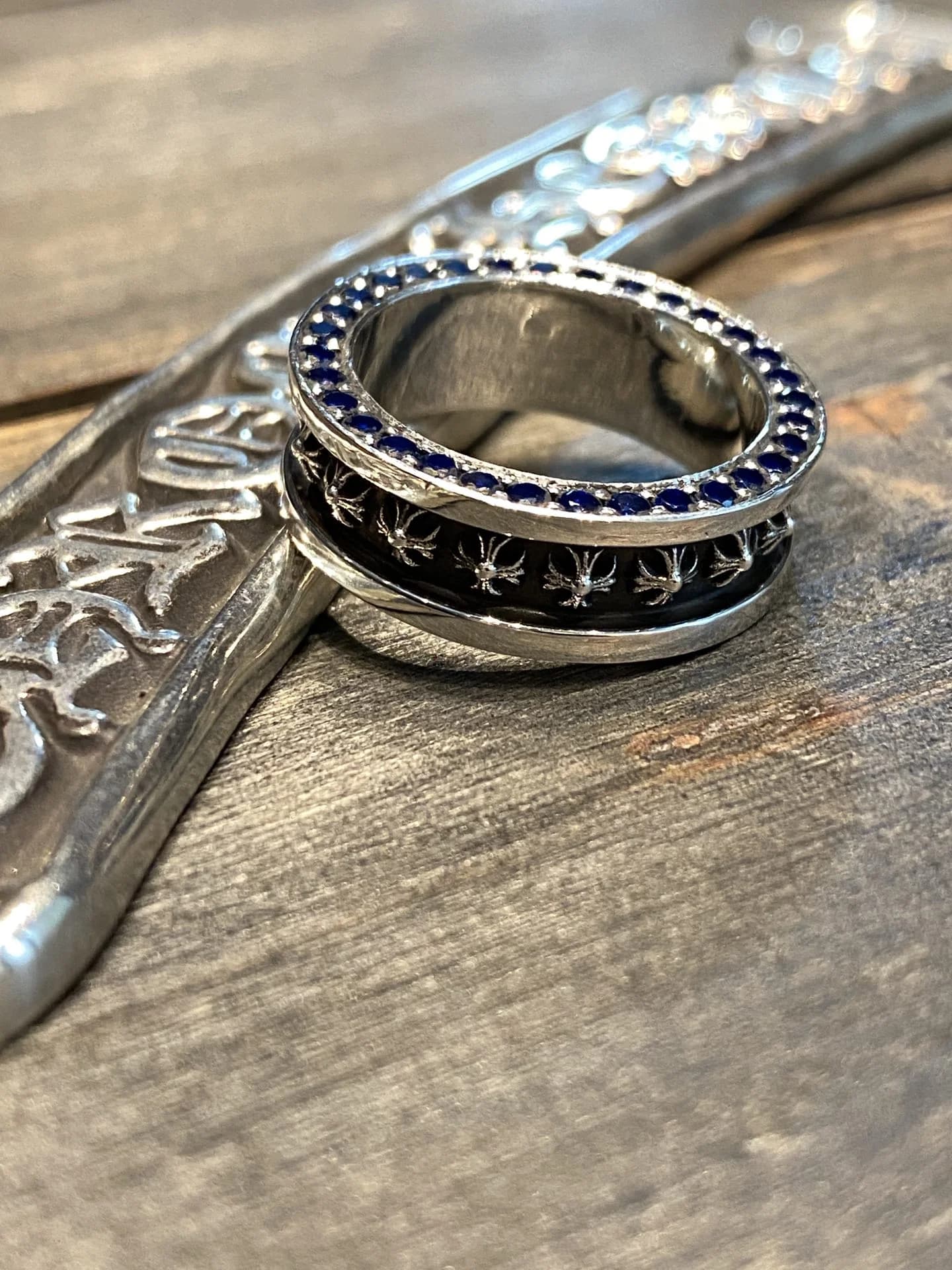 Рельефный узор с крестами и инкрустация синими камнями на кольце Chrome Hearts