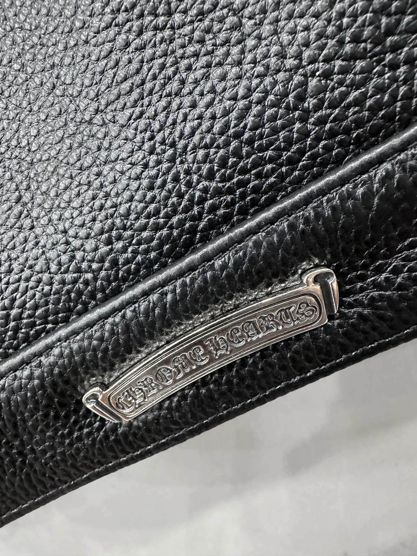 Металлическая плашка с гравировкой Chrome Hearts на нижнем крае куртки