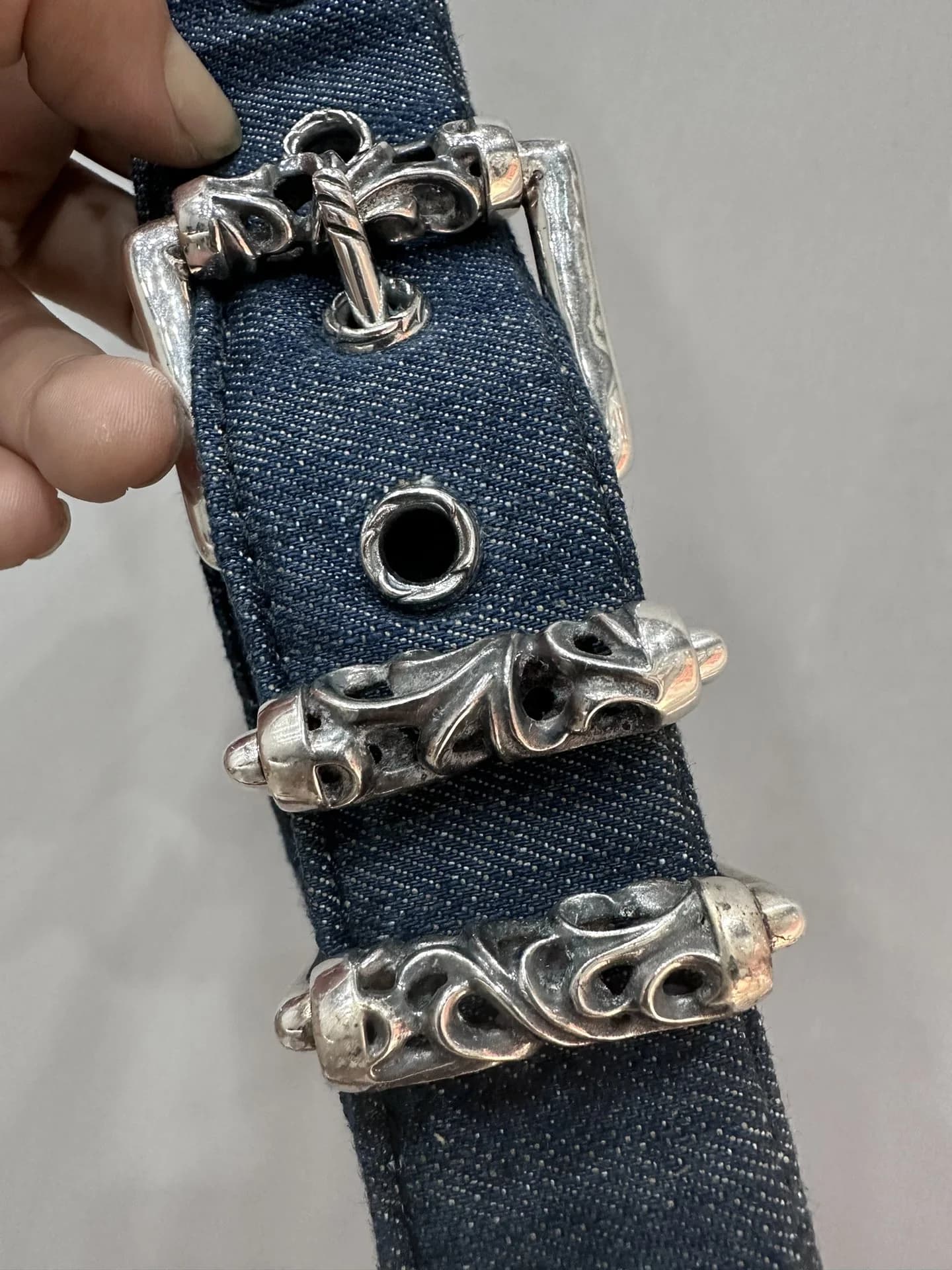 Пряжка-роллер и серебряные шлевки на синем джинсовом ремне Chrome Hearts