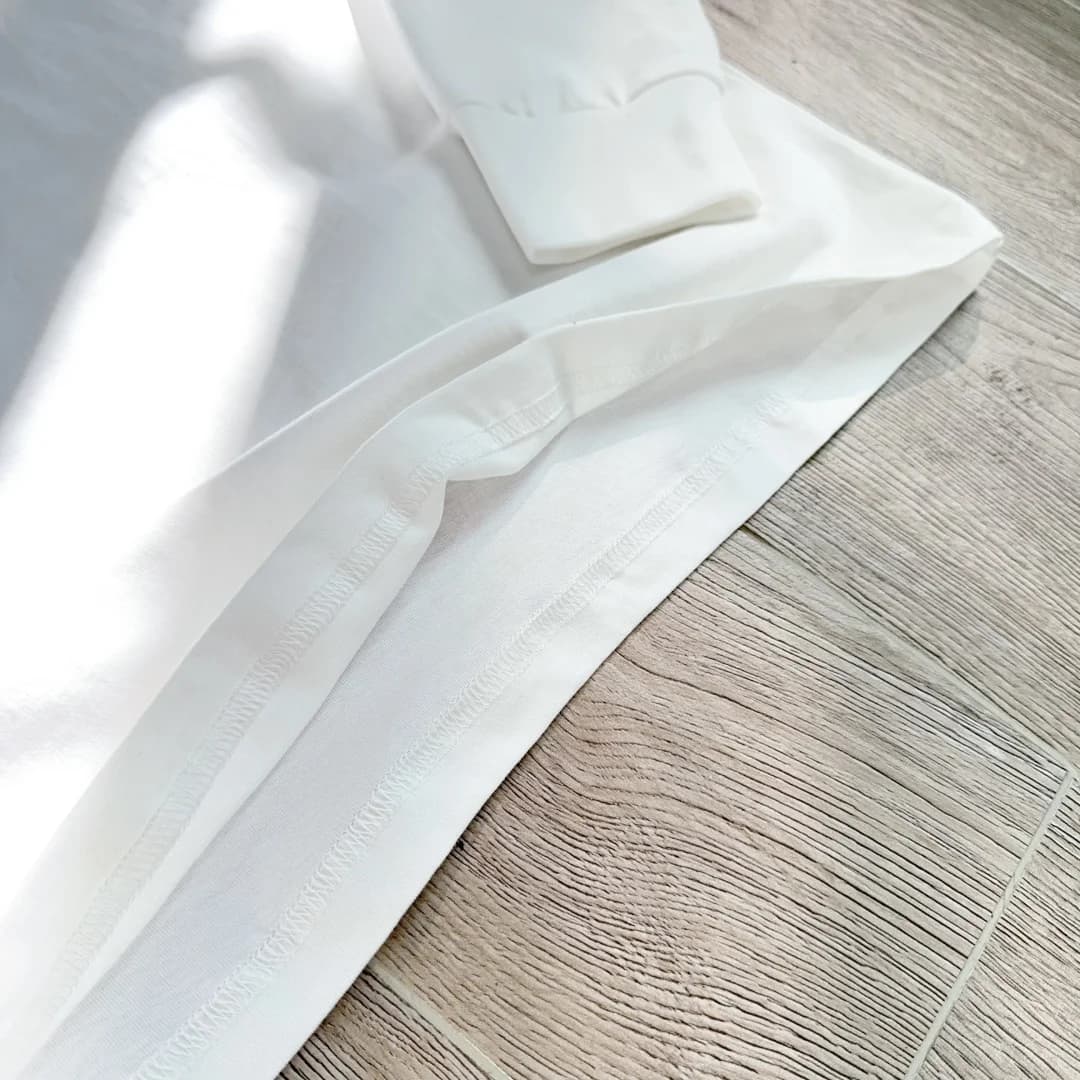 Швы на подгибе низа лонгслива Chrome Hearts, крупный план
