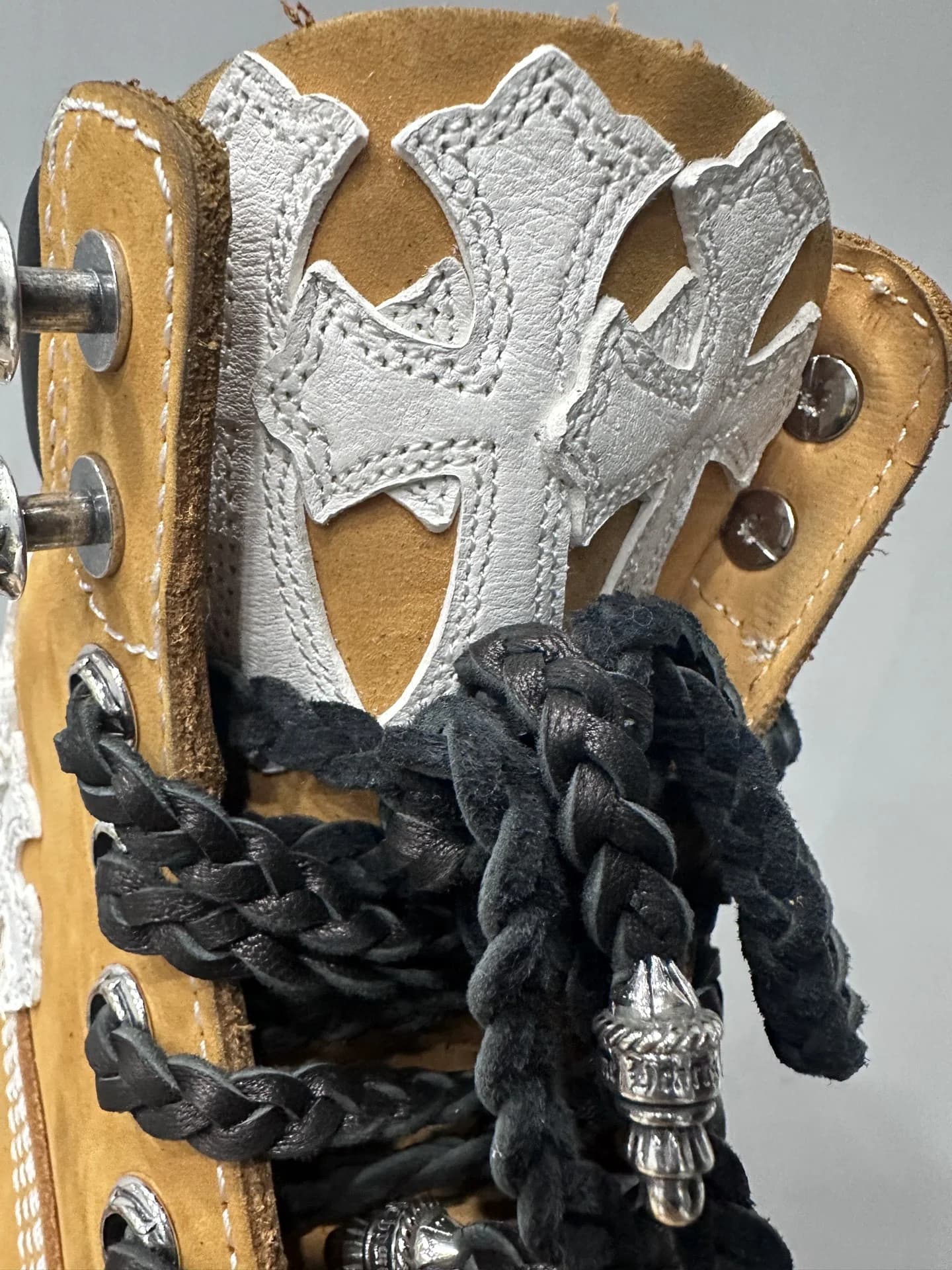 Деталь язычка ботинка Chrome Hearts x Timberland с белой кожаной нашивкой-крестом