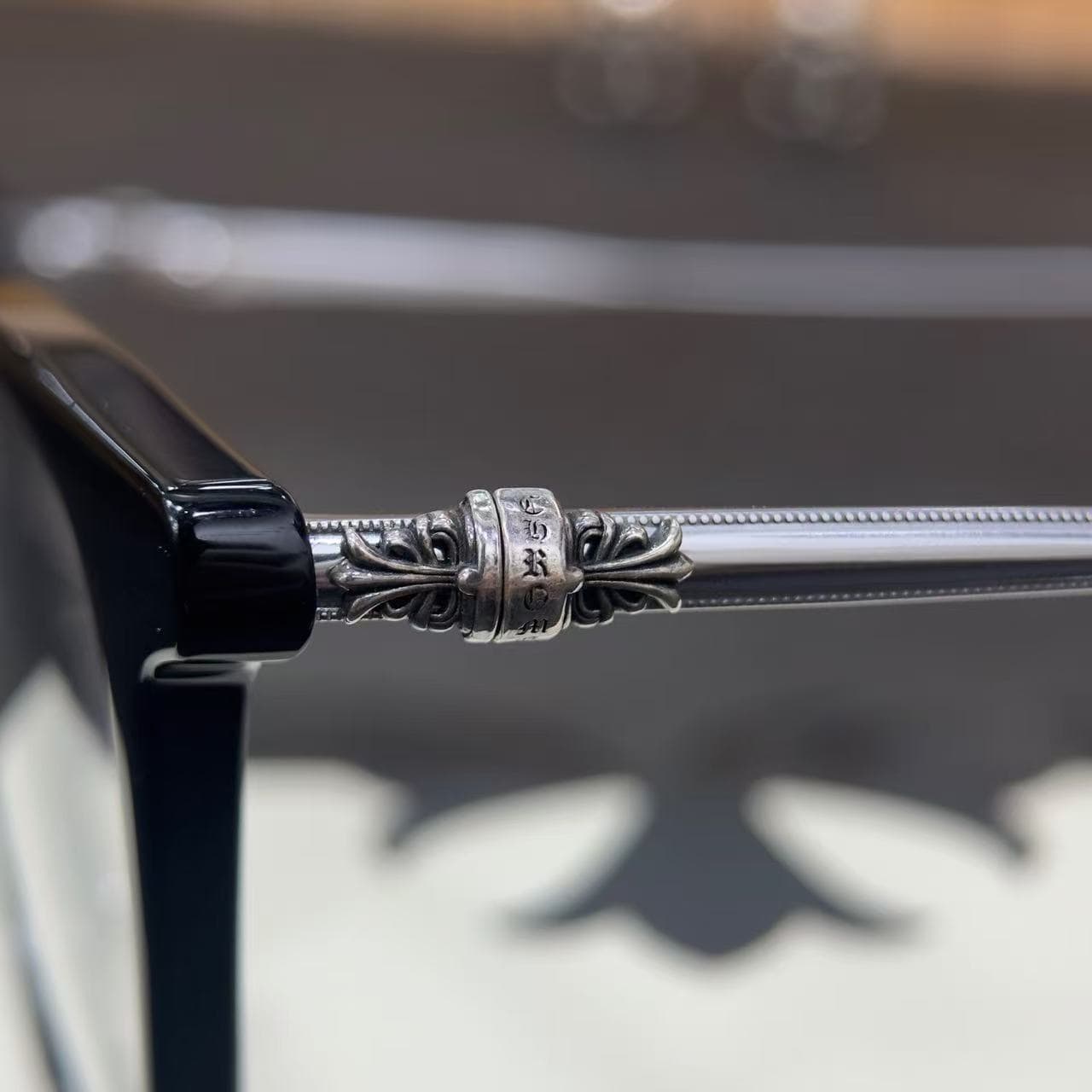 Деталь серебряного декоративного элемента на креплении дужки очков Chrome Hearts