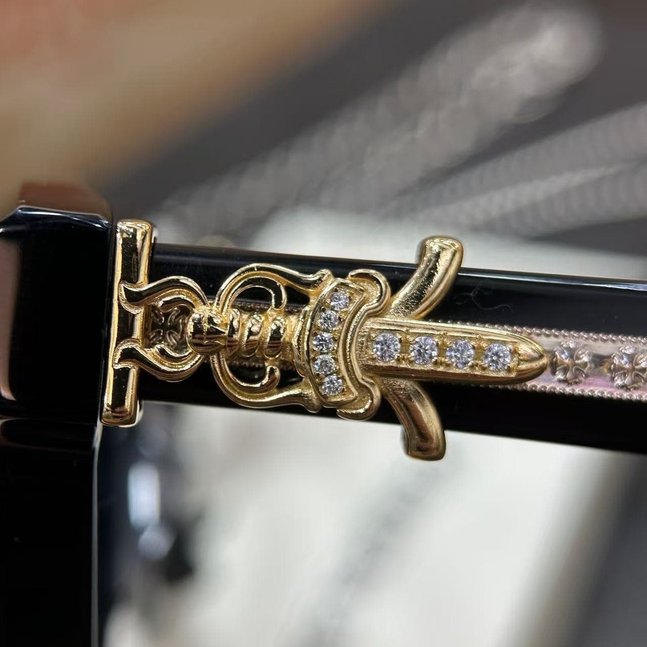 Крупный план золотистого декора в виде кинжала Dagger с инкрустацией на заушнике