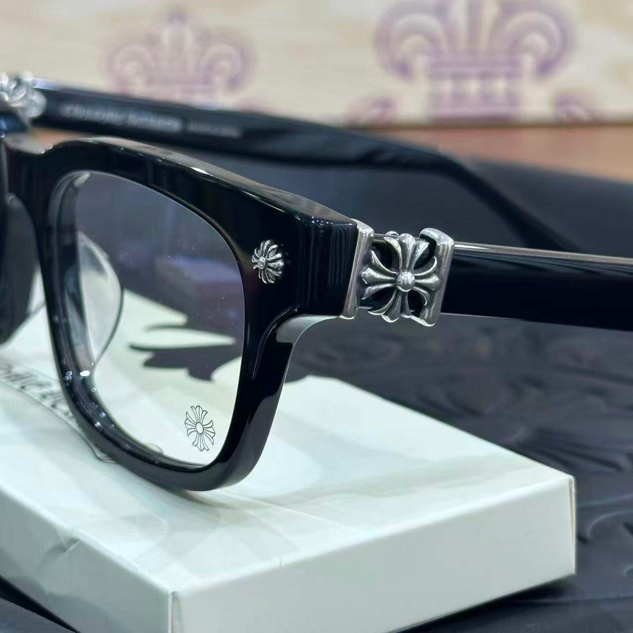 Крупный план серебряной детали 925 пробы в виде креста на дужке очков Chrome Hearts