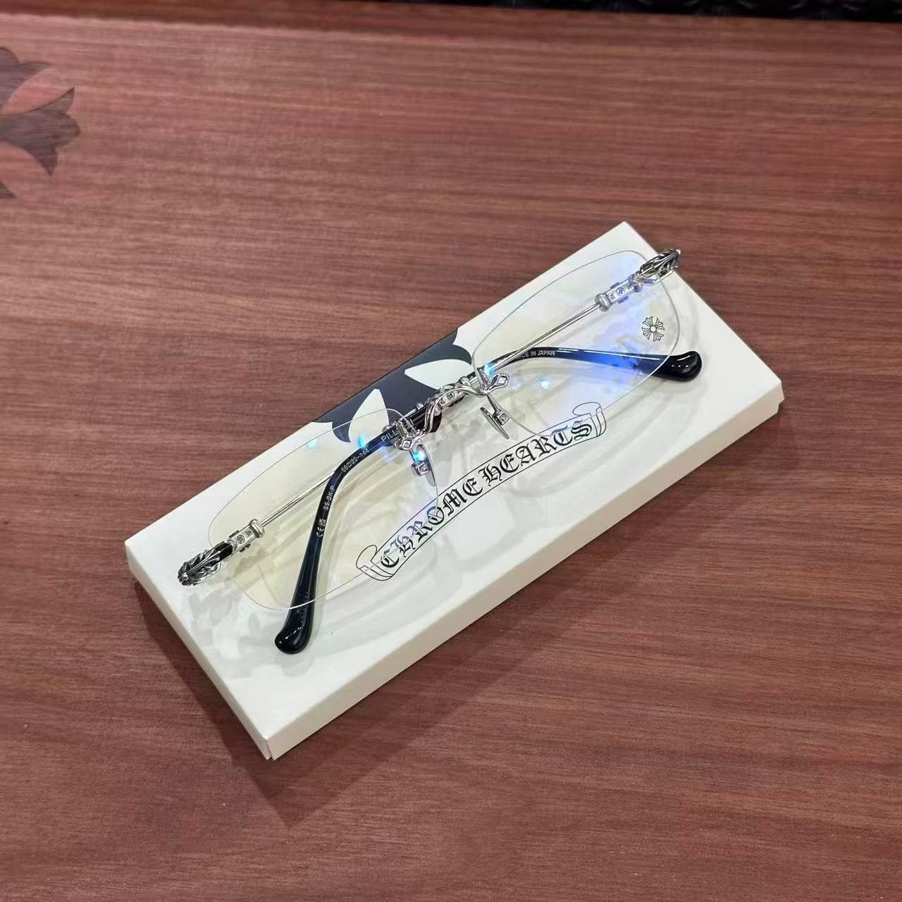 Вид сверху на безободковые очки Chrome Hearts PILLS III на подставке