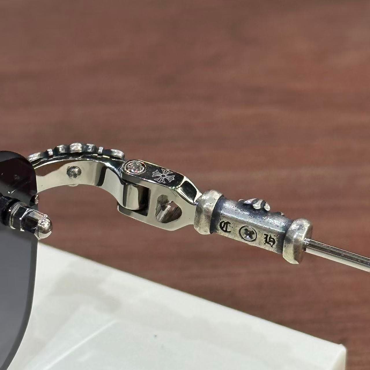 Деталь шарнира и серебряной вставки дужки очков Chrome Hearts PILLS III