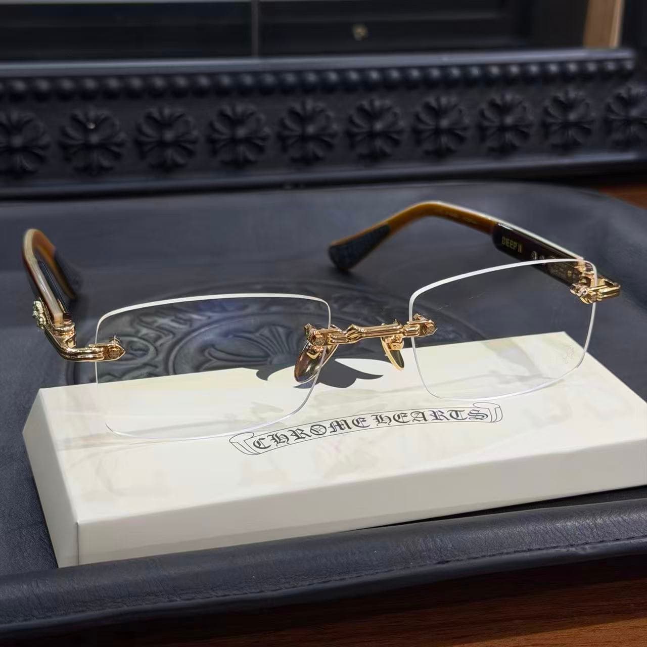 Фронтально-угловой вид очков Chrome Hearts DEEP II на белой подставке