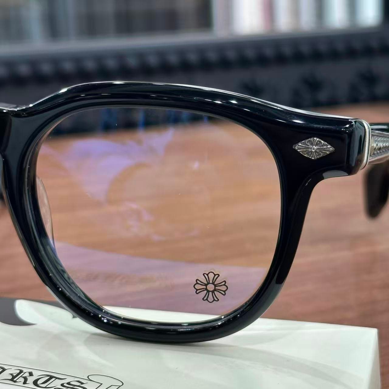 Крупный план оправы и прозрачной линзы с гравировкой логотипа Chrome Hearts