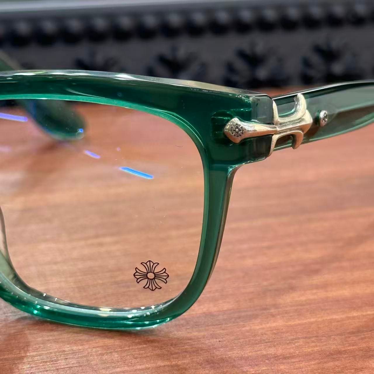 Деталь ободка и линза очков Chrome Hearts с фирменной гравировкой