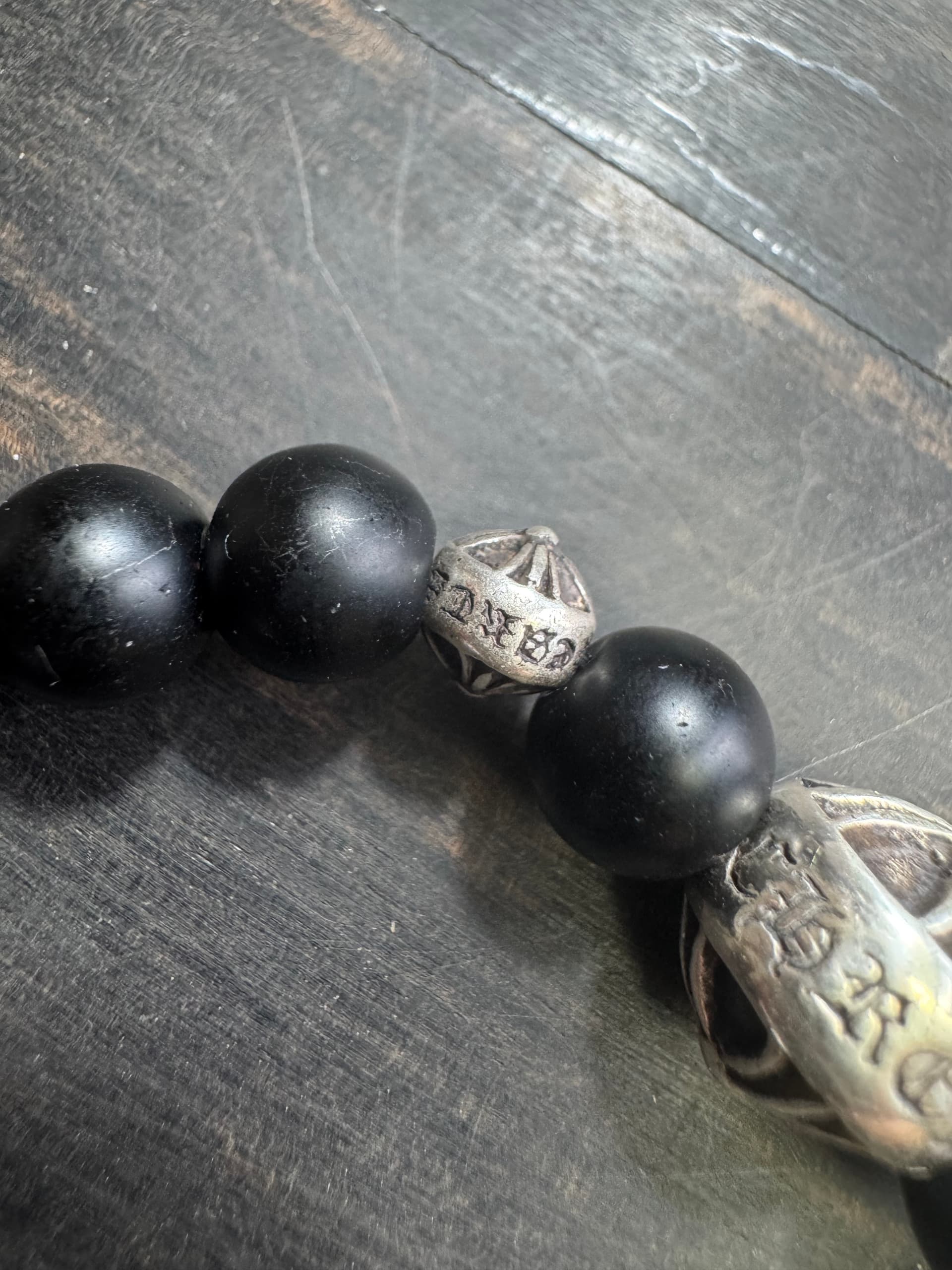 Фрагмент браслета Chrome Hearts с серебряной бусиной с гравировкой крупным планом