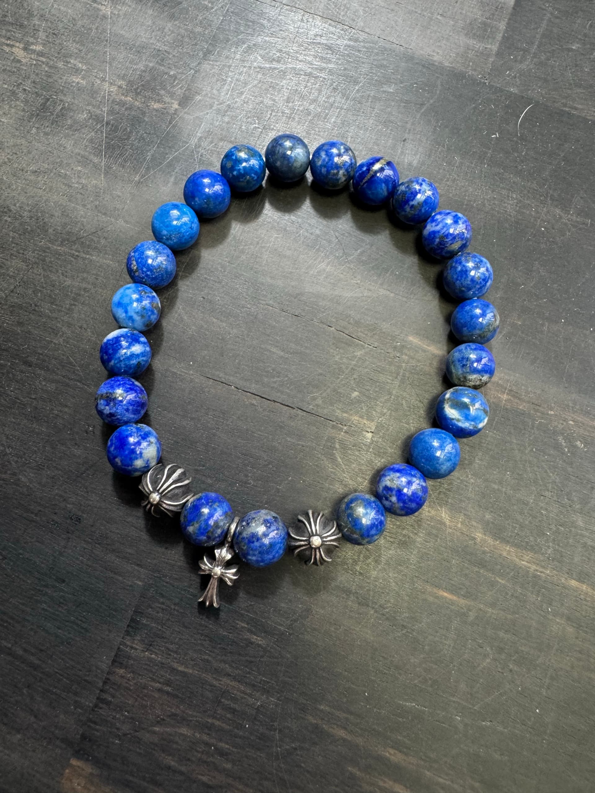 Браслет из натурального лазурита с серебряными элементами Chrome Hearts на деревянном фоне
