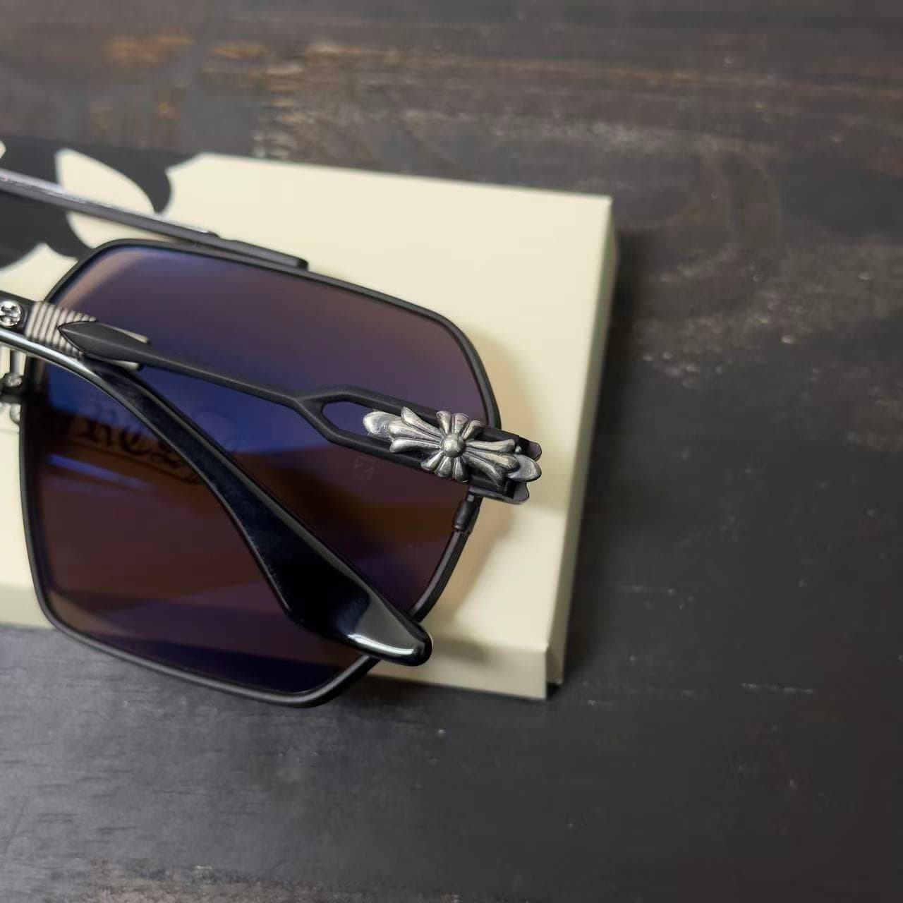 Крупный план серебряного декоративного элемента на дужке очков Chrome Hearts