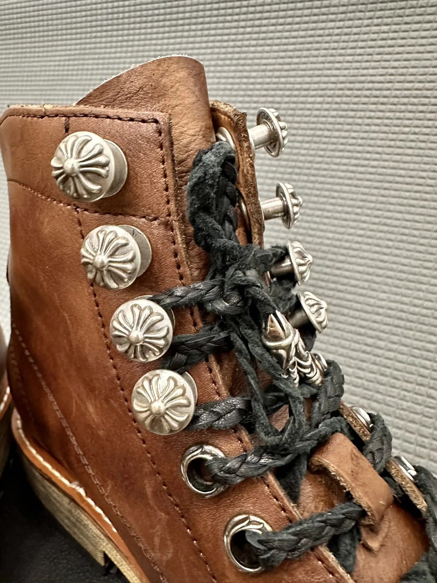 Крупный план серебряных заклепок-крестов на ботинках Chrome Hearts