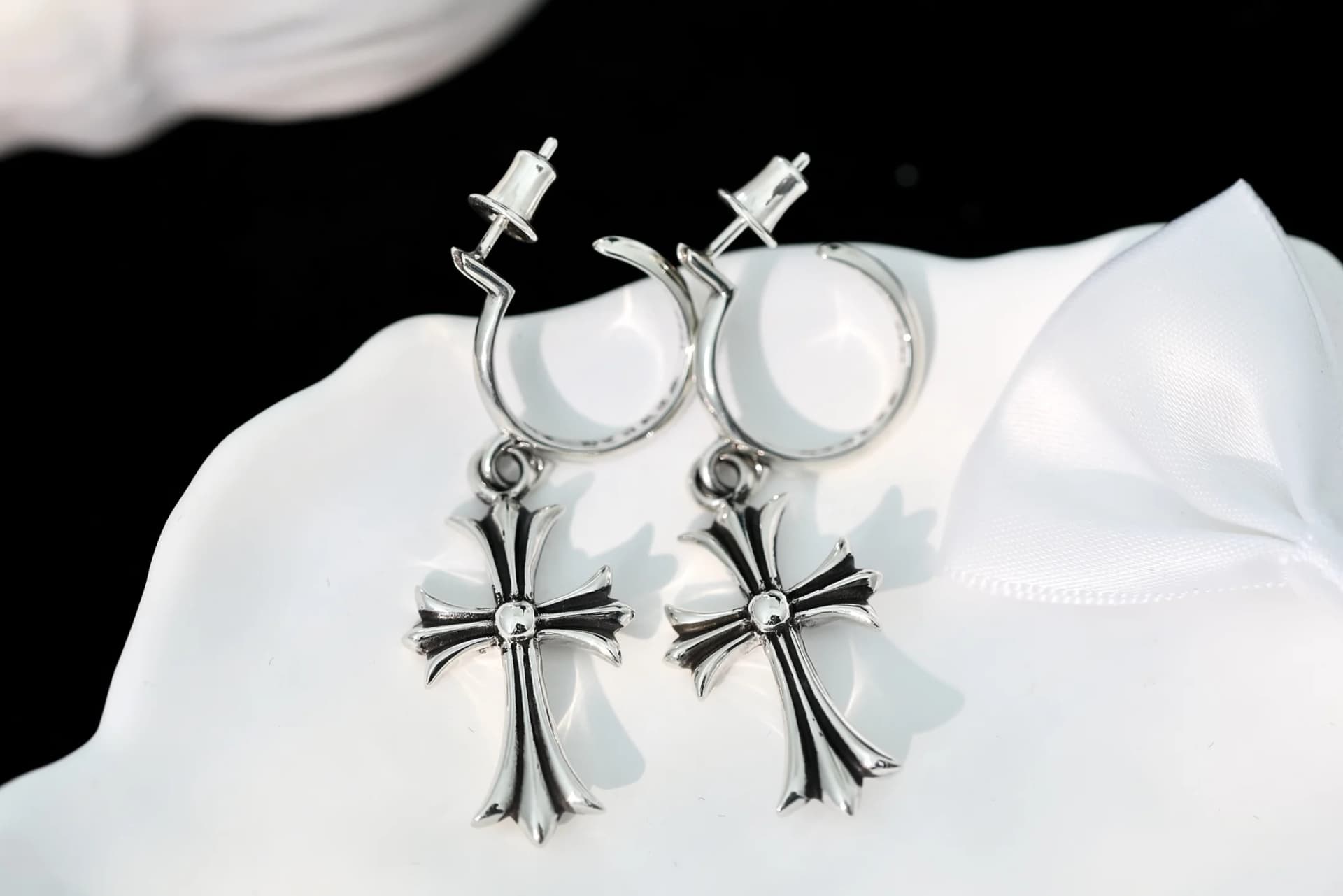 Крупный план пары серебряных серег Chrome Hearts