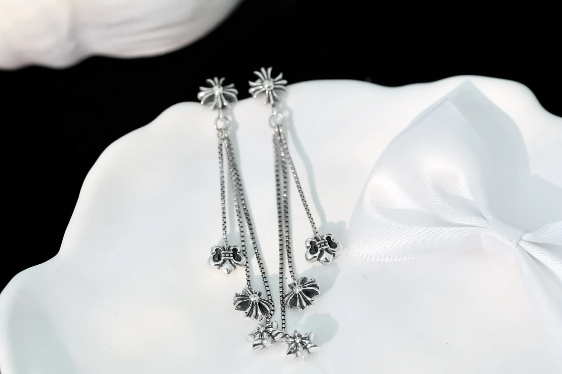 Пара серег Chrome Hearts с подвесками-цепочками на белом блюде
