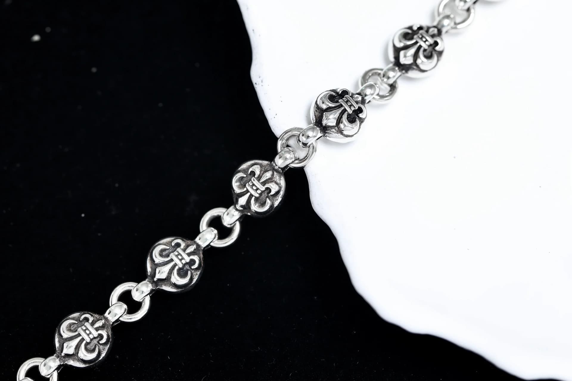 Крупный план декоративных звеньев серебряного браслета Chrome Hearts