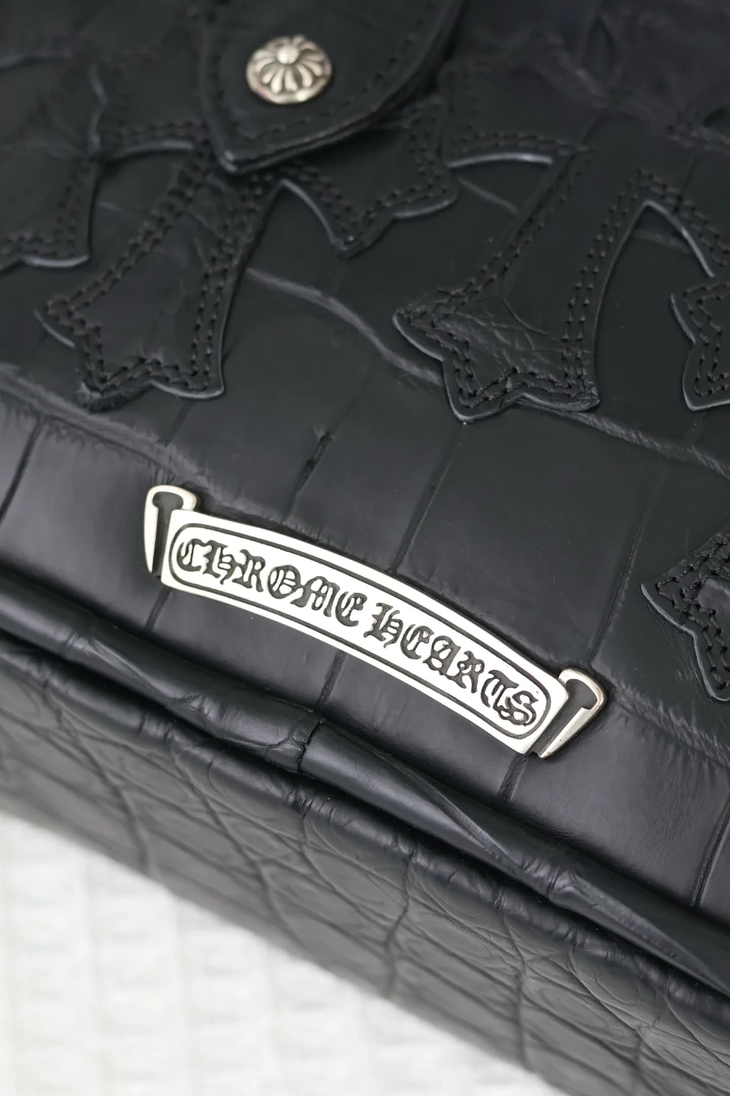 Серебряная плакетка с гравировкой Chrome Hearts на корпусе сумки