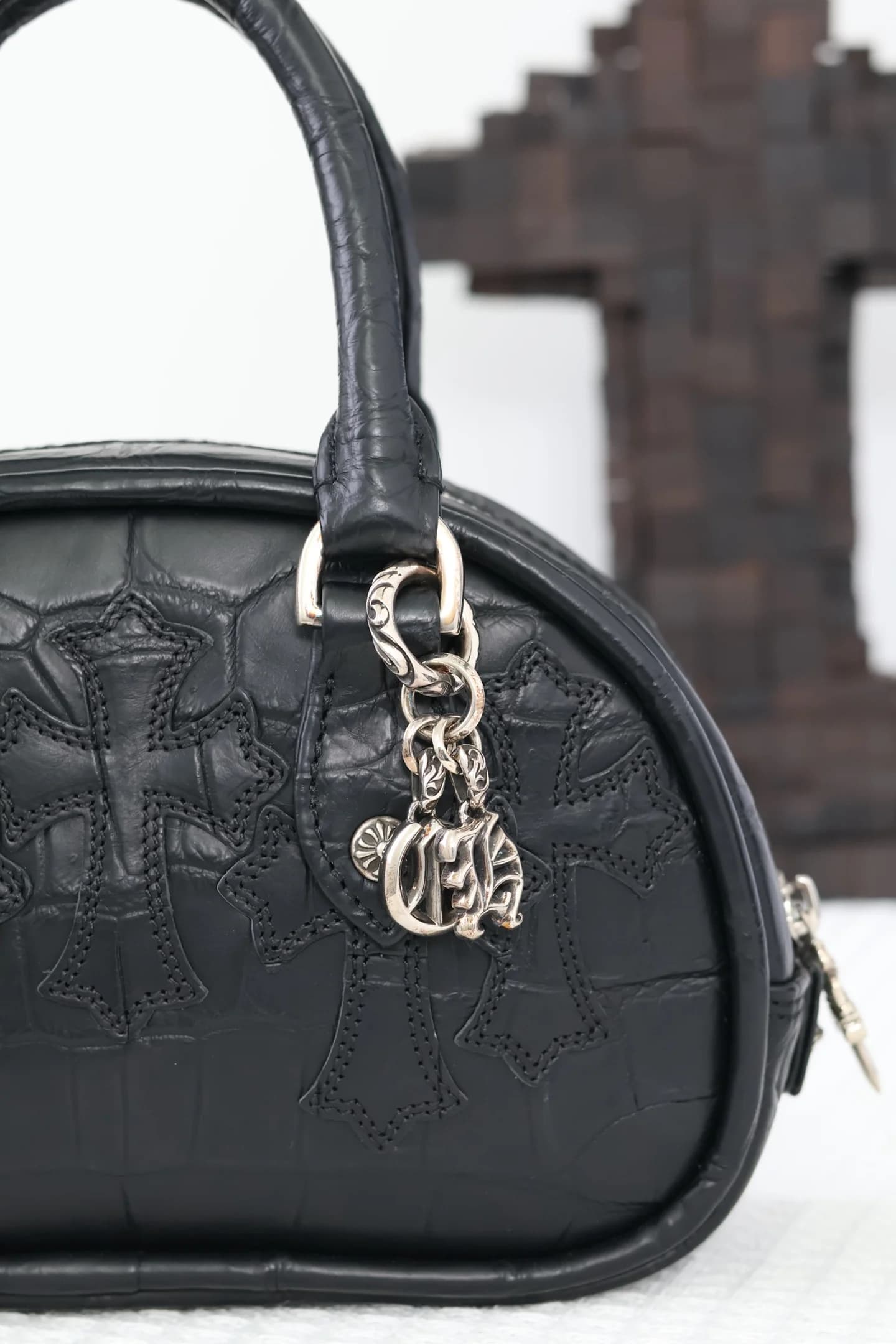 Боковой профиль сумки Chrome Hearts с серебряными подвесками