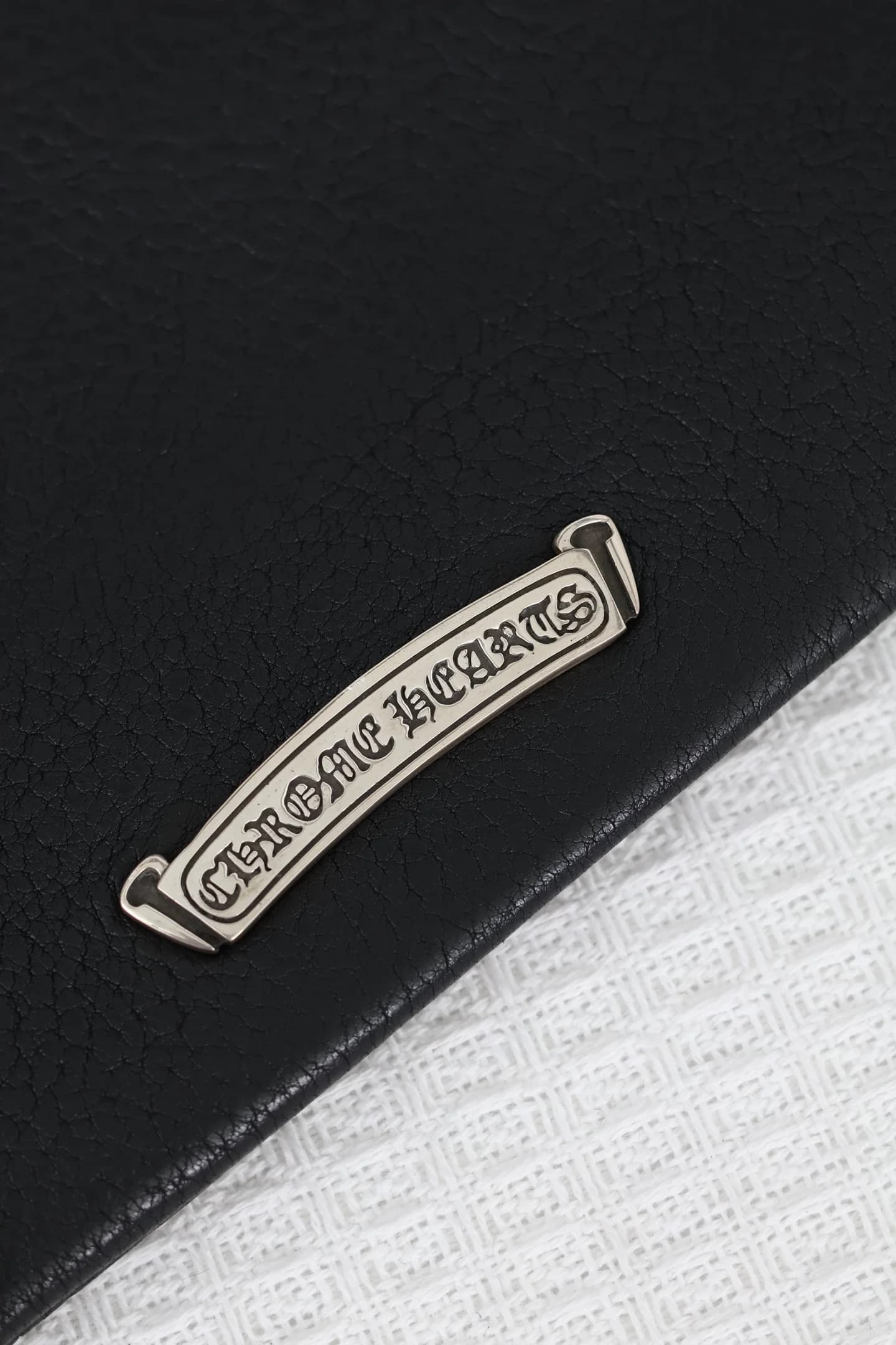 Серебряная фигурная плашка с гравировкой Chrome Hearts на задней стороне сумки
