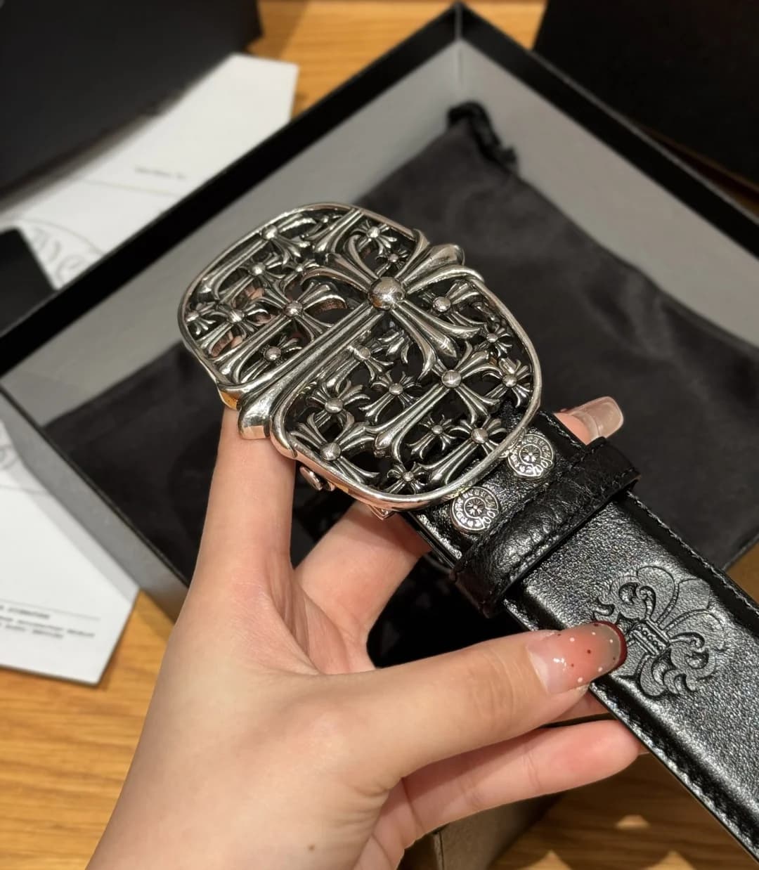 Крупный план резной серебристой пряжки и кожаной отделки ремня Chrome Hearts