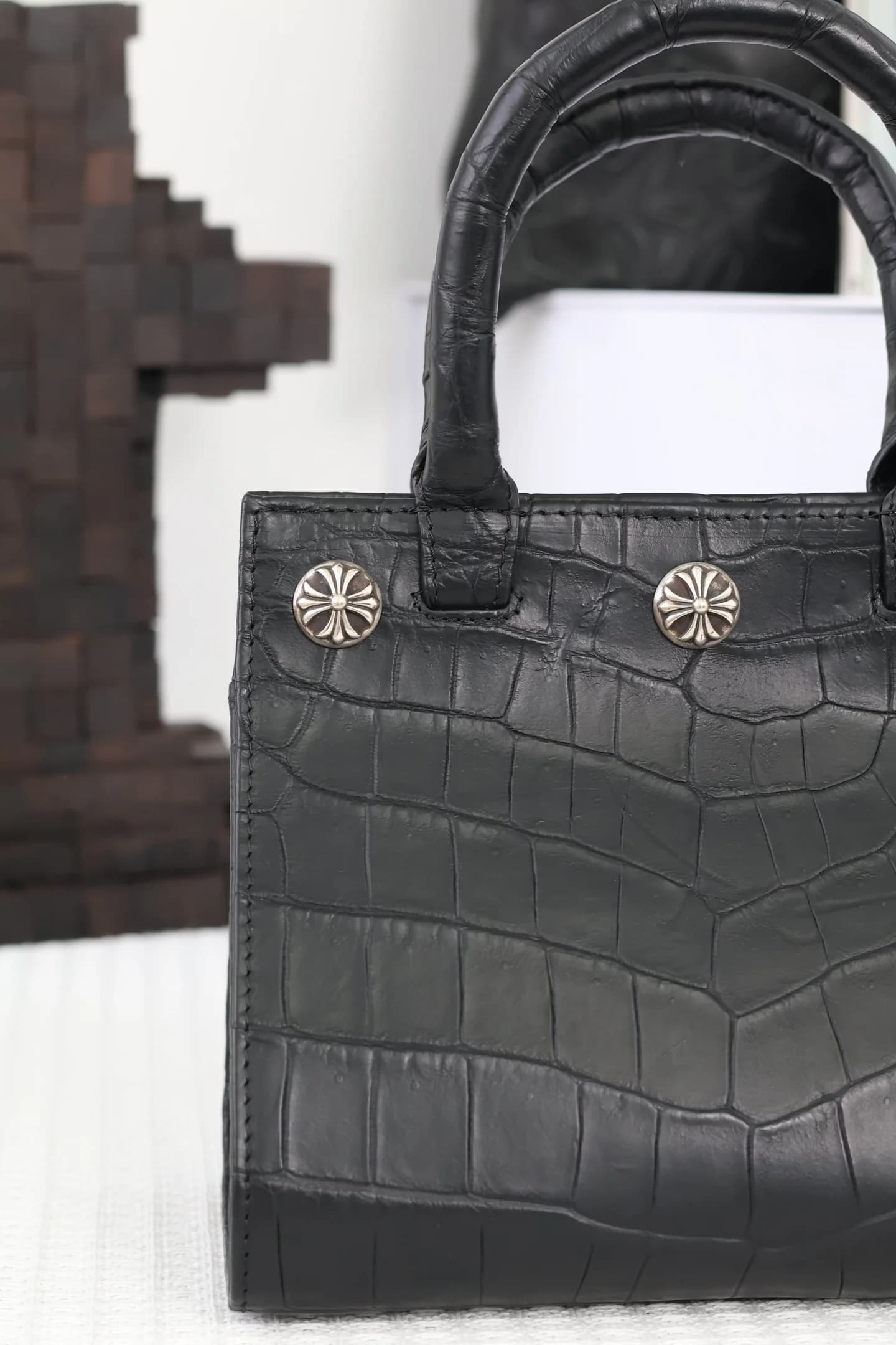 Крепление ручки черной сумки Chrome Hearts с серебряными деталями