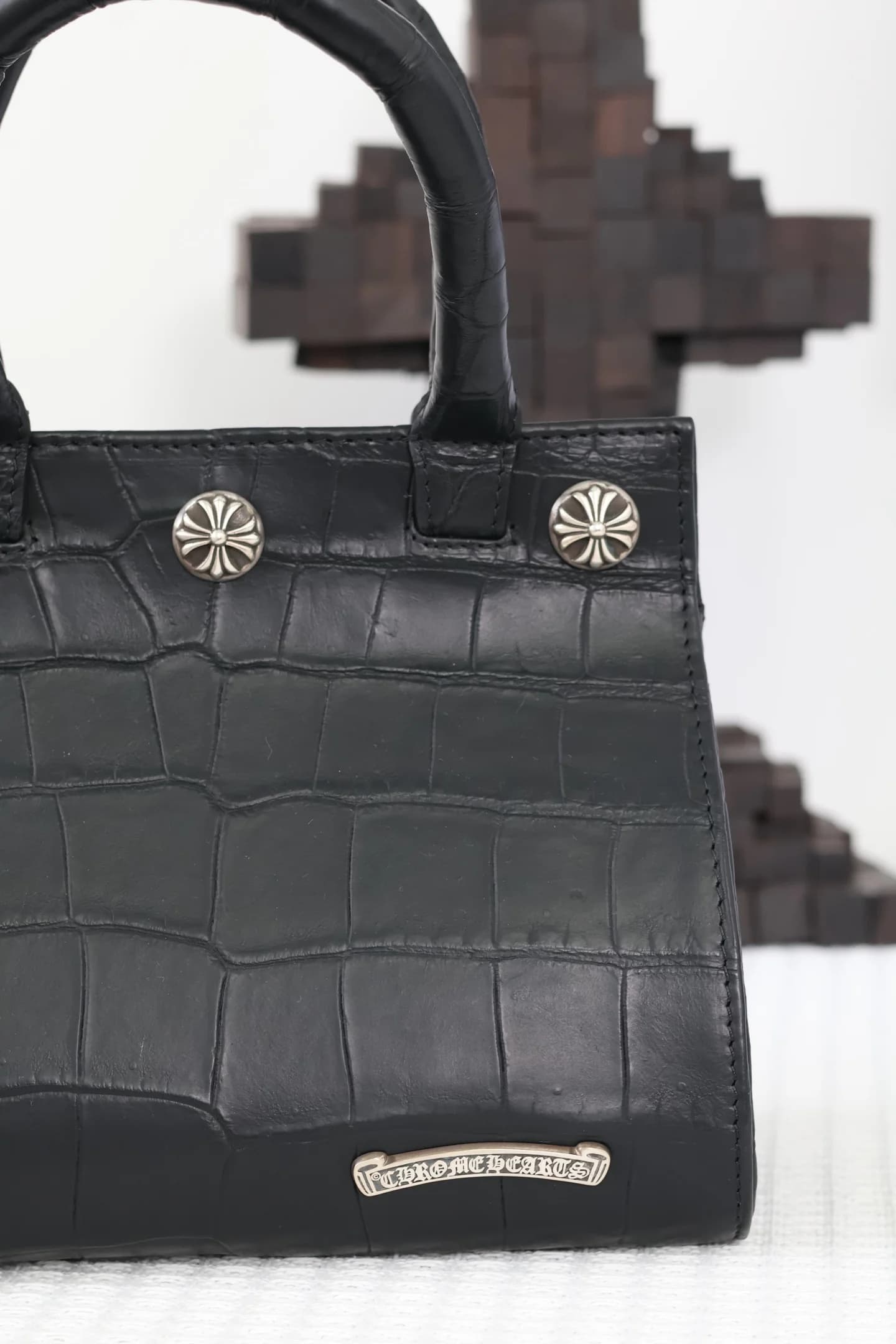 Нижняя часть сумки Chrome Hearts с серебряным логотипом-свитком