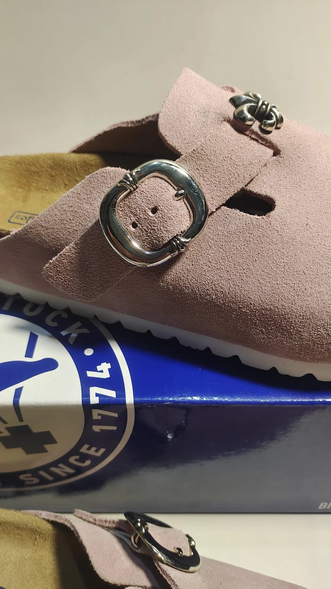 Крупный план серебряной пряжки на розовых сабо Chrome Hearts x Birkenstock Boston