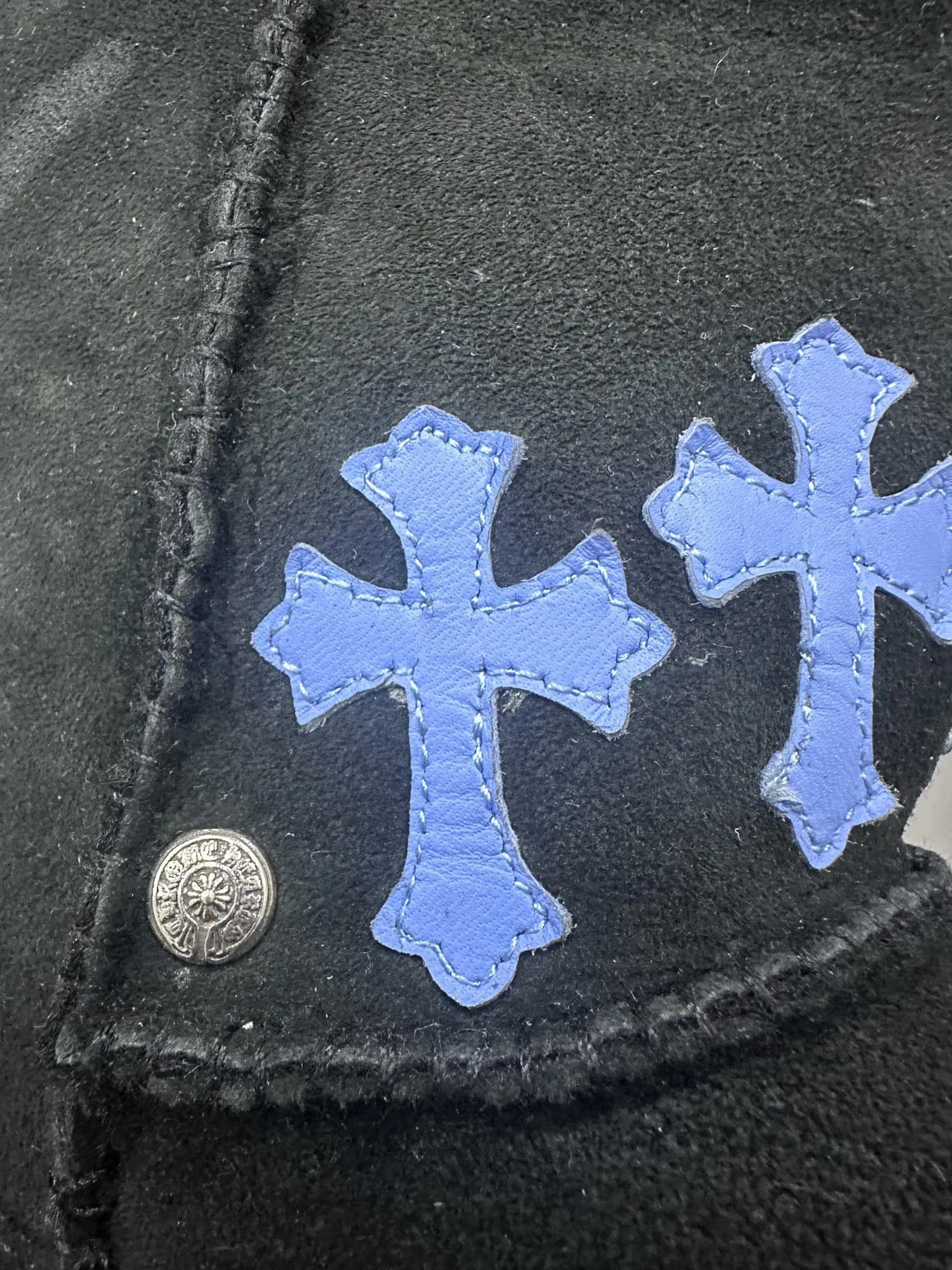 Деталь синей кожаной нашивки в виде креста на сапогах Chrome Hearts x UGG