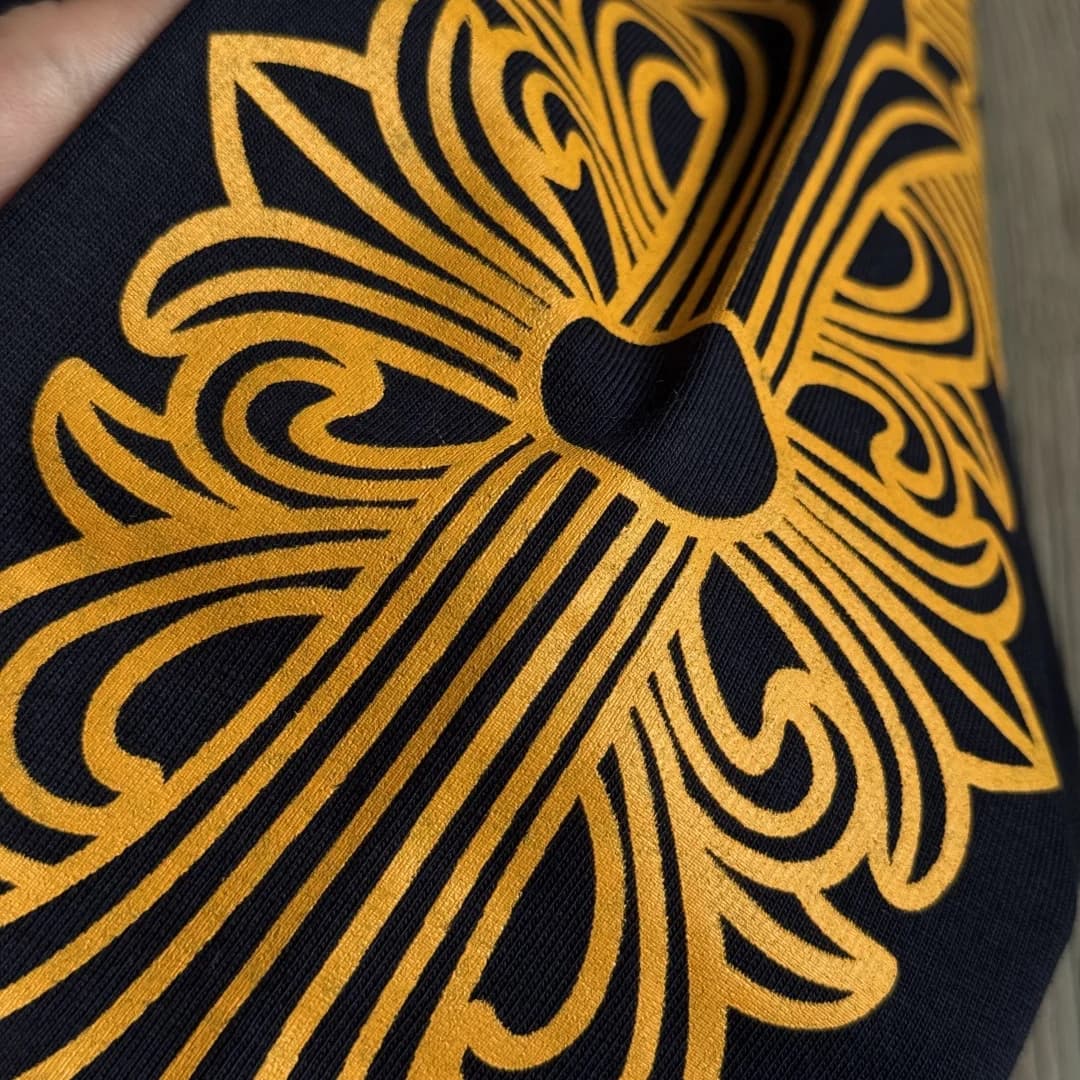 Крупный план желтого принта на рукаве лонгслива Chrome Hearts