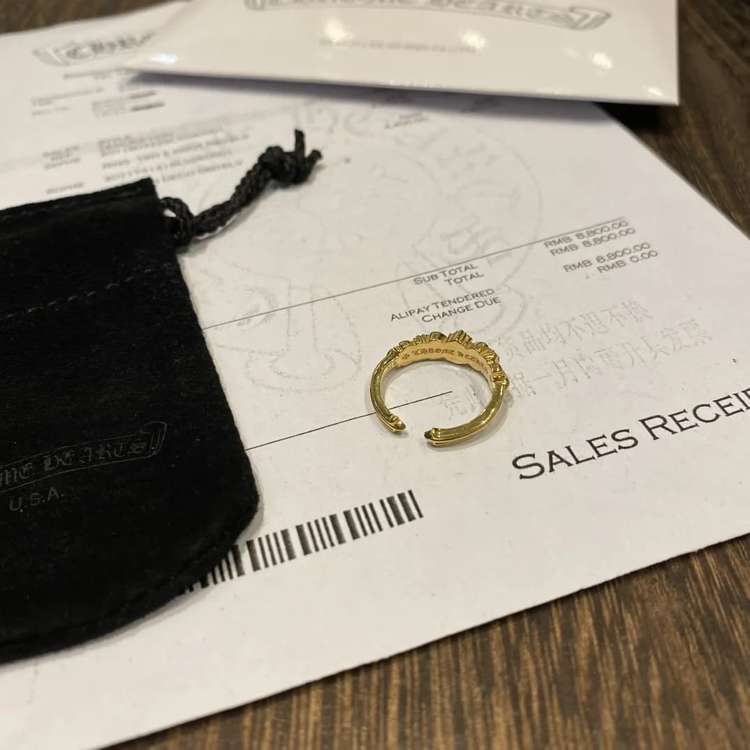 Вид сверху на разомкнутое кольцо Chrome Hearts из желтого золота с бриллиантами и чеком
