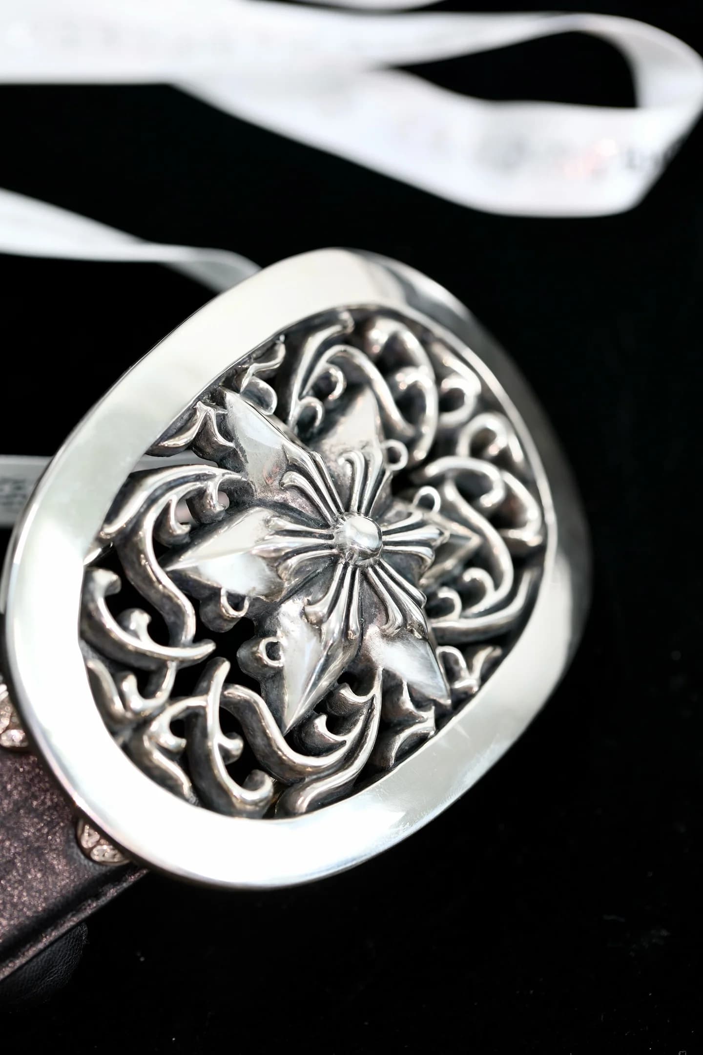Массивная овальная пряжка ремня Chrome Hearts с резным узором и звездой крупным планом