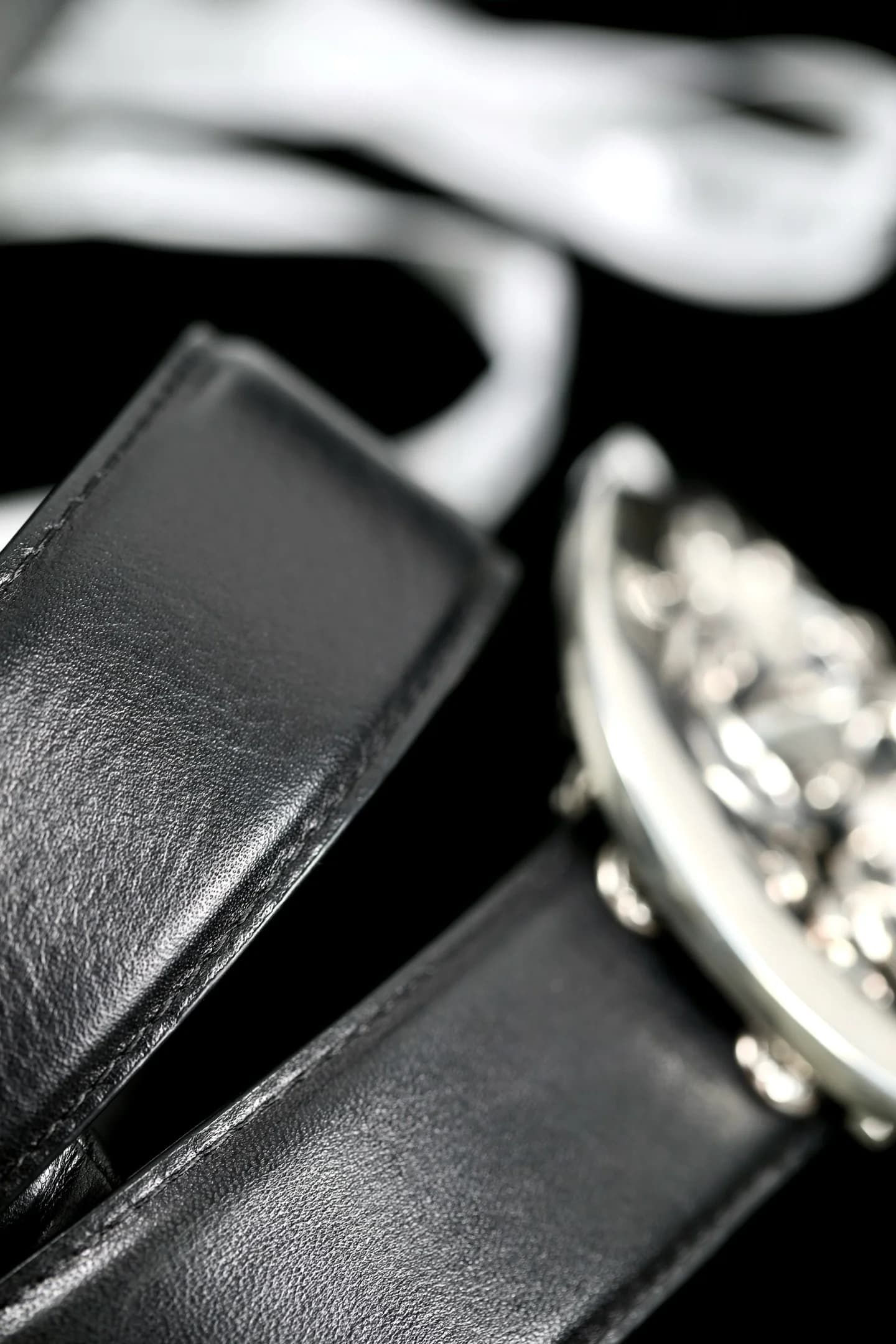 Фактура черной натуральной кожи полотна ремня Chrome Hearts рядом с пряжкой