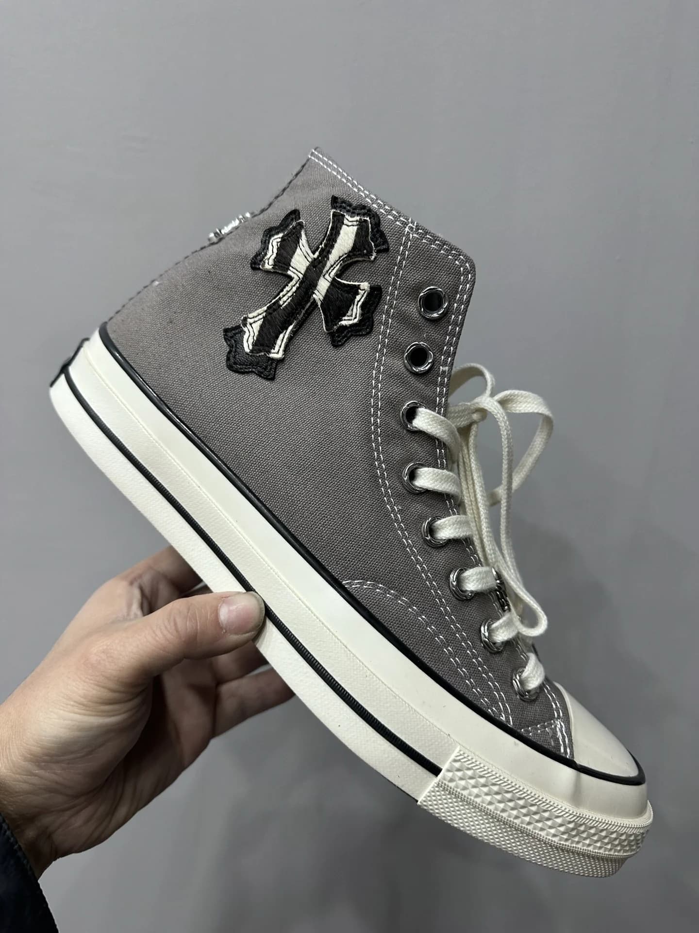 Деталь кед Chrome Hearts x Converse Chuck 70 с кожаной нашивкой в виде креста