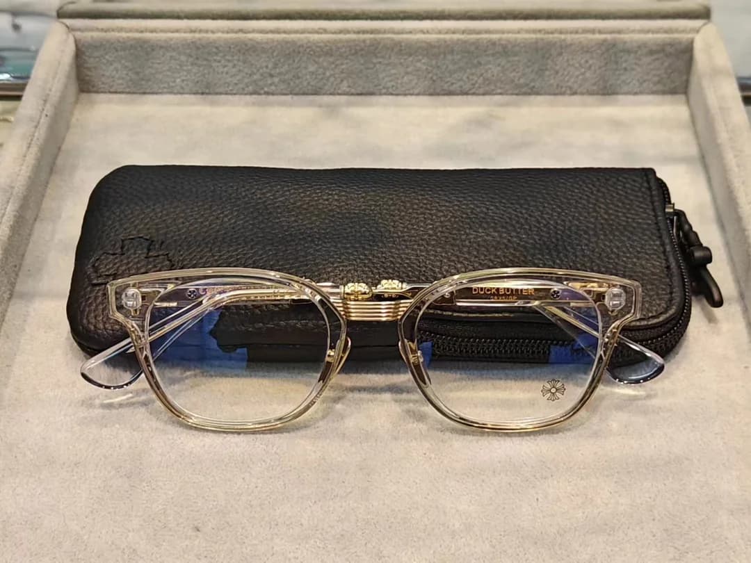 Очки Chrome Hearts Duck Butter в прозрачно-золотистой оправе на фоне кожаного чехла