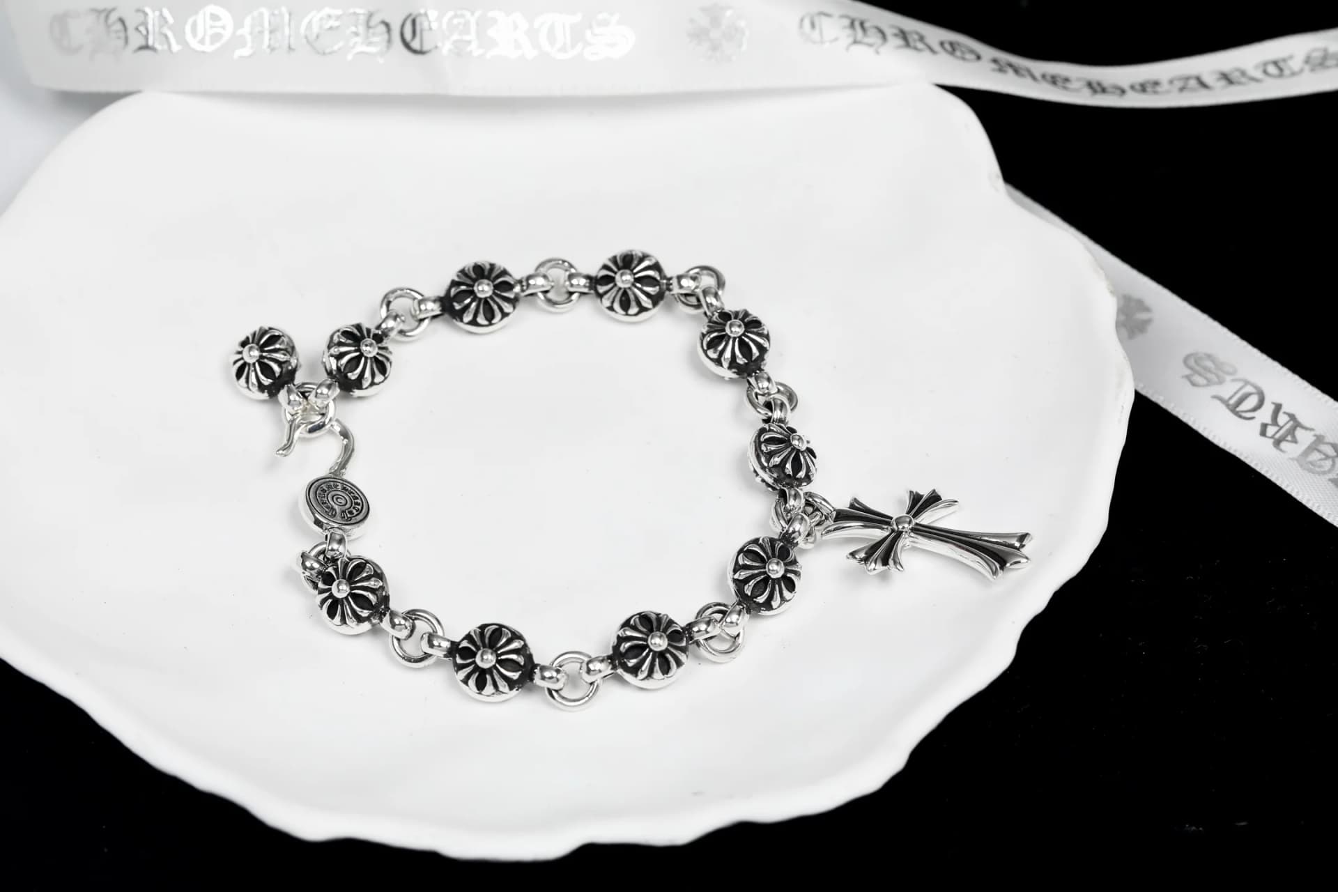 Серебряный браслет Chrome Hearts со звеньями Cross Ball и подвеской-крестом на белой подставке