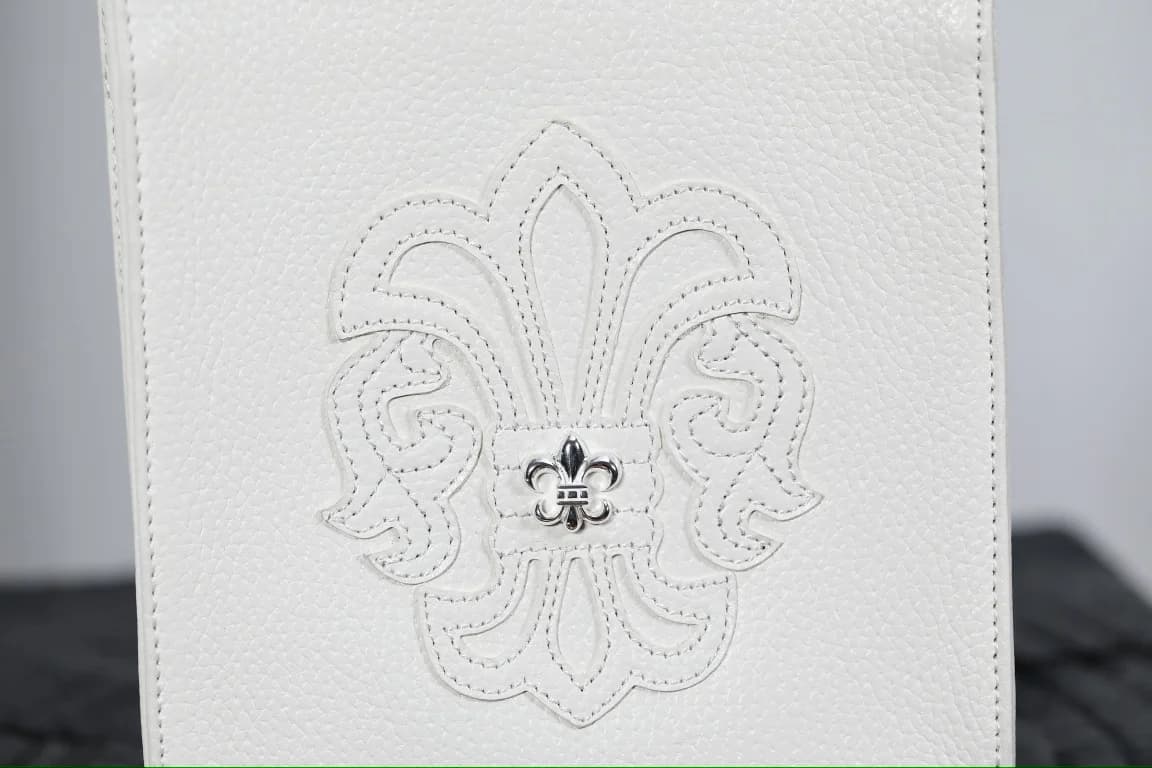 Крупный план кожаной аппликации Fleur с серебряным элементом на сумке Chrome Hearts