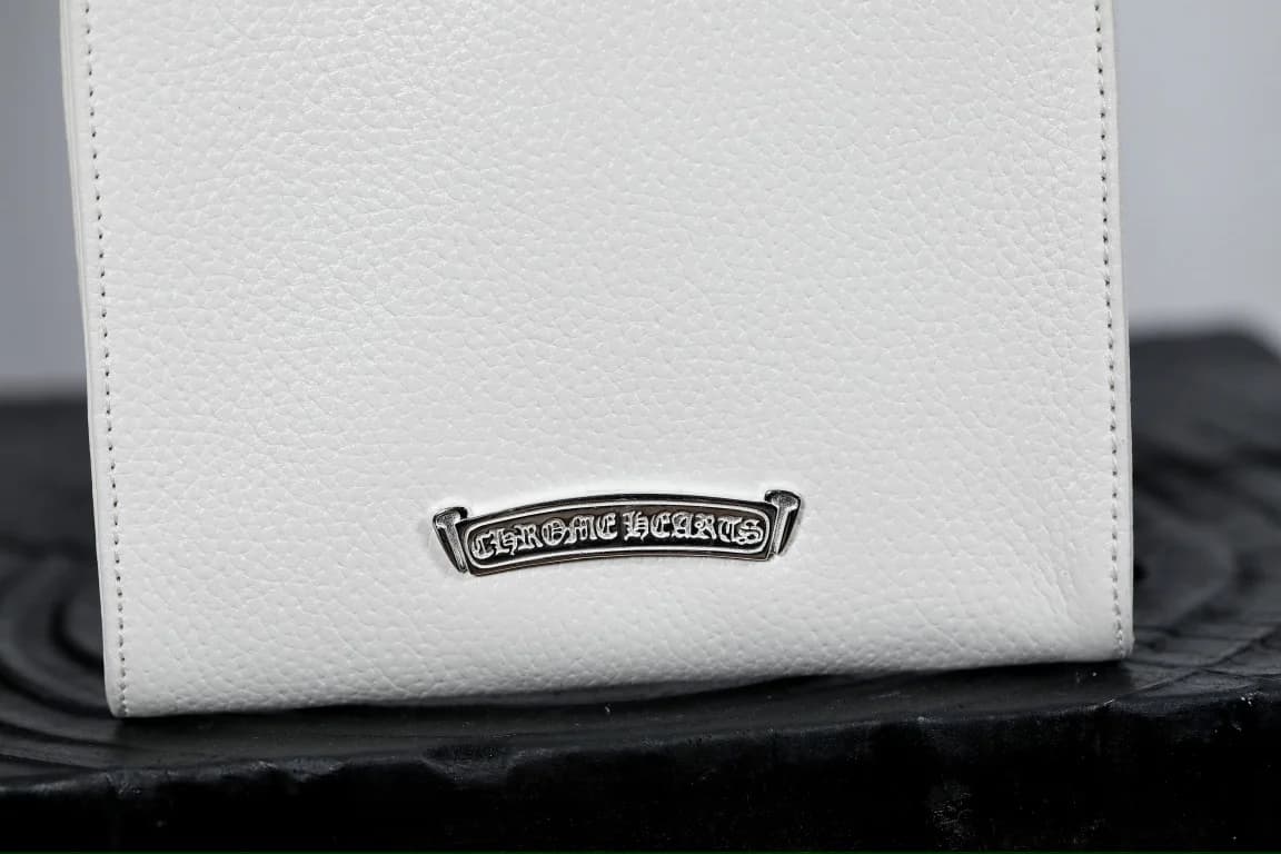 Фирменный серебряный шильд Chrome Hearts на белой зернистой коже