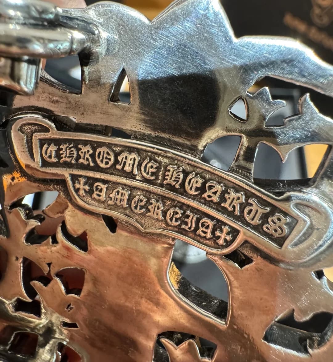 Деталь гравировки бренда на металлической пряжке ремня Chrome Hearts