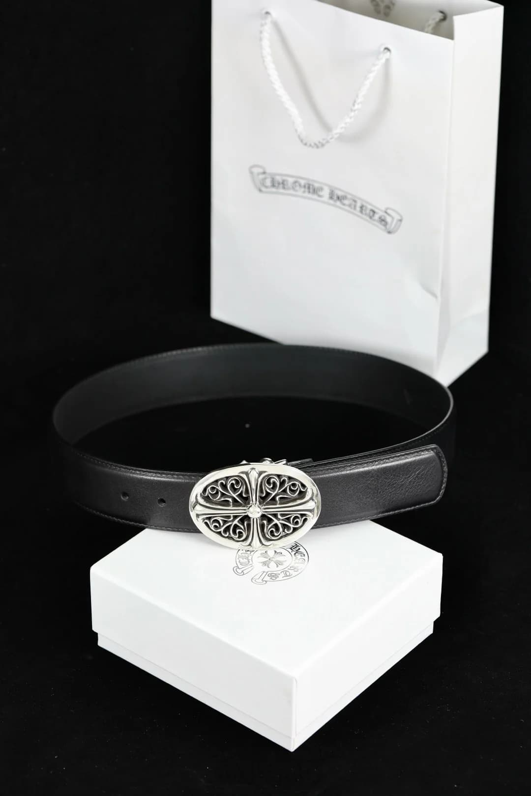 Кожаный ремень Chrome Hearts с овальной серебряной пряжкой на фоне фирменной упаковки