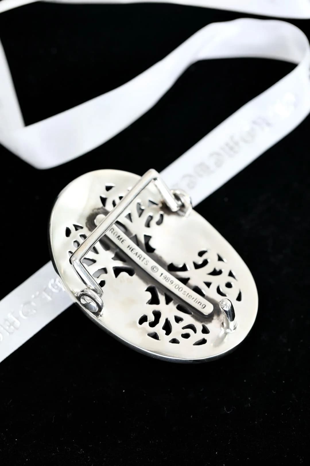 Гравировка бренда на обратной стороне серебряной пряжки Chrome Hearts